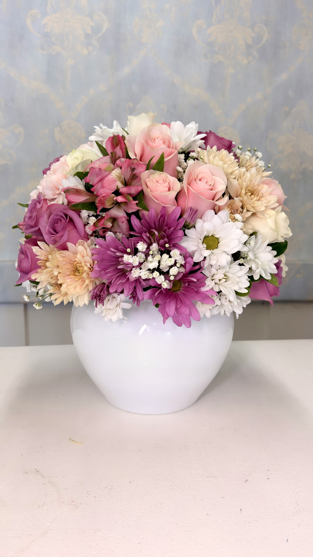 Sweet Blossom - Brighten someone’s day with our beautiful Sweet Blossom arrangement  Designed in an elegant modern base, this floral arrangement features a gorgeous mix of roses in different shades, fresh daisies, carnations, alstroemerias, and seasonal flowers carefully arranged to create a soft, colorful, and romantic design.  Perfect for birthdays, Mother’s Day, thank you gifts, or simply making someone feel special.   A delicate, cheerful, and elegant arrangement that brings beauty and happiness to any space.