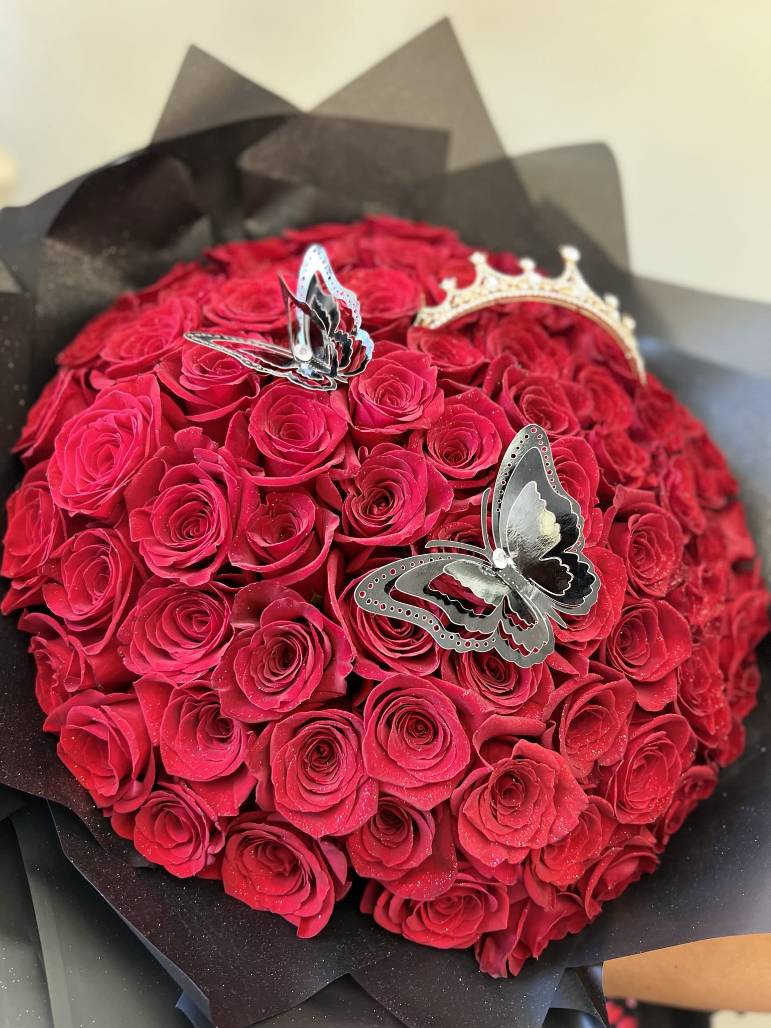 Round bouquet of red roses with butterfly decorations