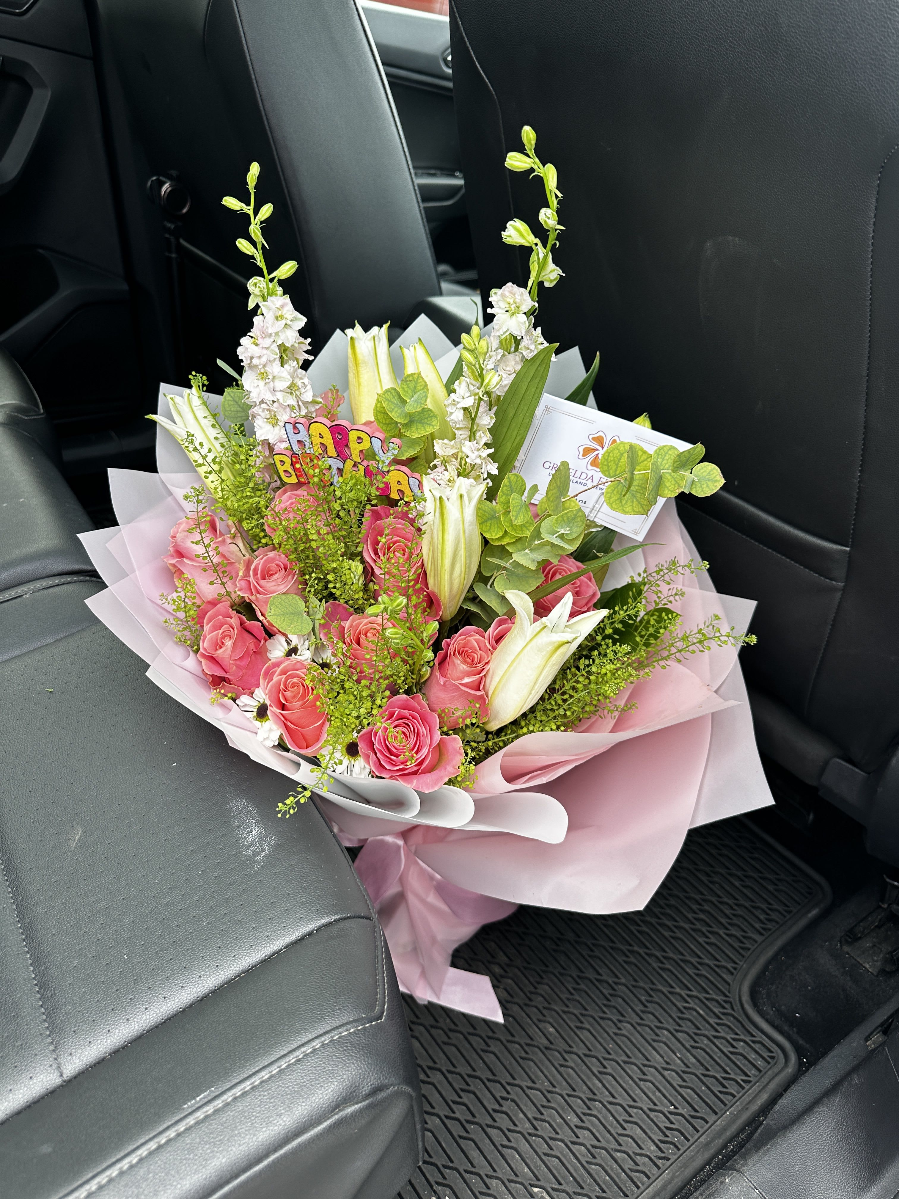 Pink rose bouquet with white lilies and a birthday topper
