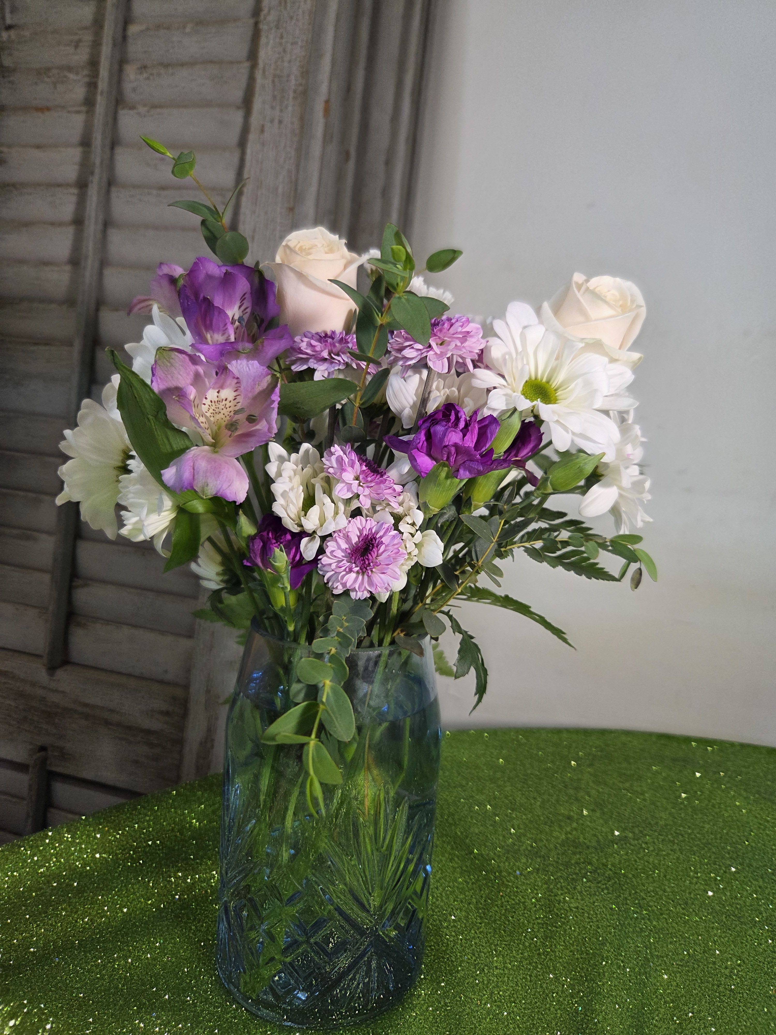 Blue Belle - Lavender, purple, and white flowers in our Blue Belle vase will show your deep feelings on this special day.