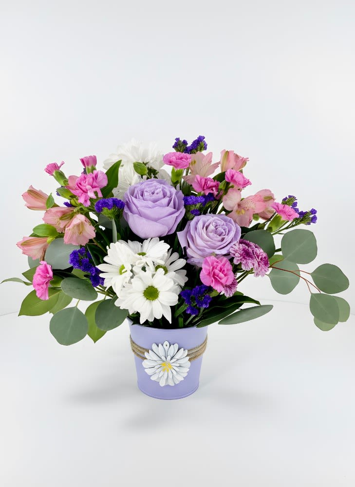 Lavender Love Bouquet - Bursting with color and personality, this cheerful garden‑style arrangement turns any day into a celebration. Lively orange roses, bold magenta and purple carnations, bright blue delphinium, and sunny white daisies gather in a charming pink watering can—creating a look that feels fresh, fun, and full of life. It’s the perfect blend of whimsy and warmth, like a little bouquet of sunshine delivered straight to the doorstep.