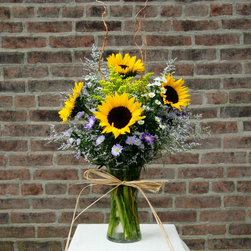 Wild at Heart - Wildflower look of limonium, curly willow, monte casino, novi belgi, solidago, sunflowers and raffia bow.