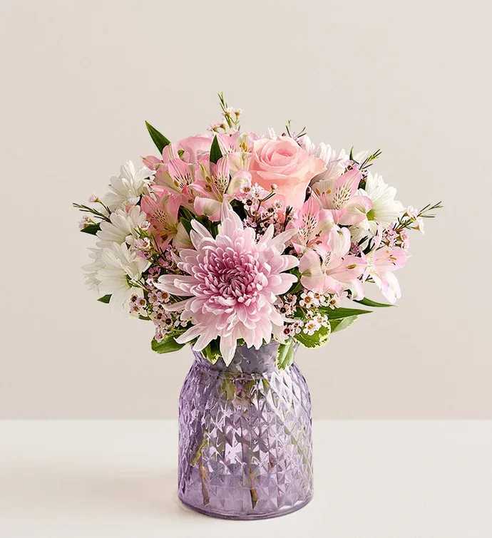 Pink and white bouquet in a purple glass vase