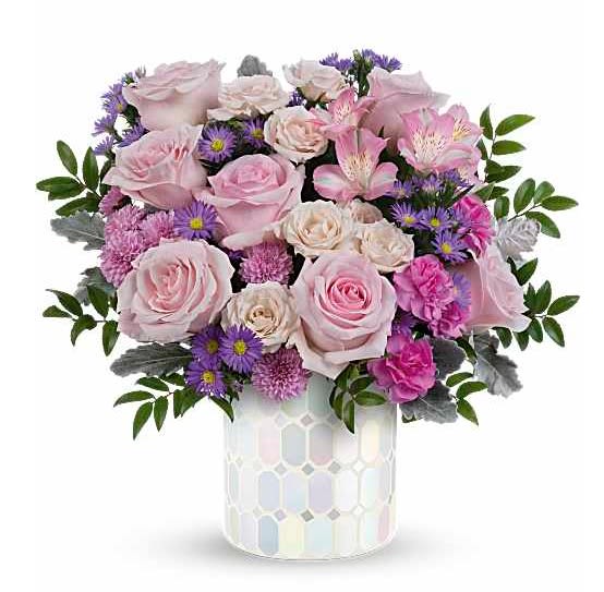 Mother’s Day Pastel Wishes - Celebrate Mom with the soft beauty and elegance of our Mother’s Day Lavender Bliss arrangement. This charming bouquet features delicate blush and lavender roses accented with vibrant purple blooms, pink carnations, seasonal floral accents, and lush greenery beautifully arranged in a modern keepsake container.  Designed to express love, gratitude, and appreciation, this arrangement brings a graceful garden-inspired touch perfect for Mother’s Day celebrations. Its soft pastel tones and fresh floral textures create a warm and heartfelt gift Mom will truly adore.