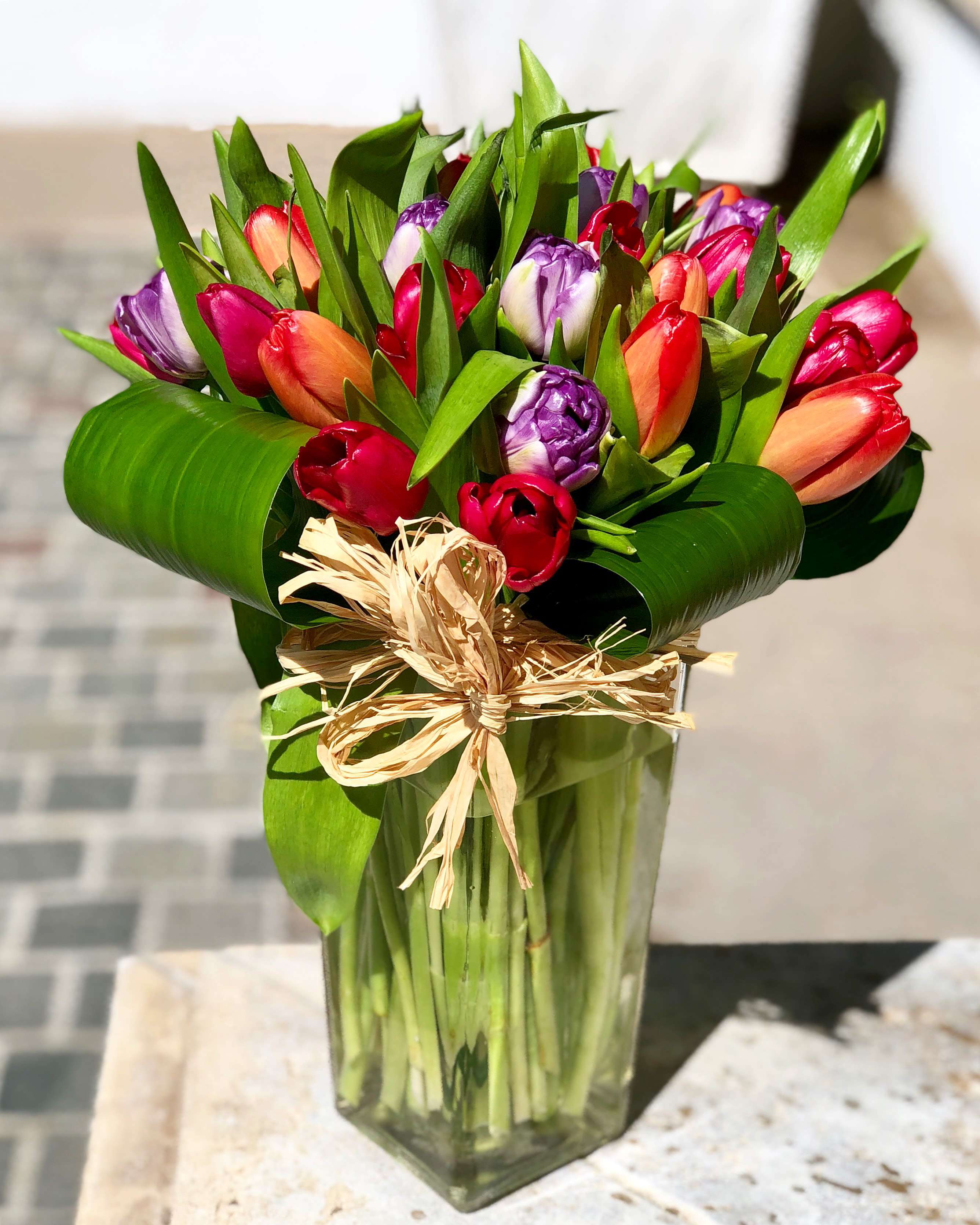 Bouquet of multicolored tulips in a clear glass vase