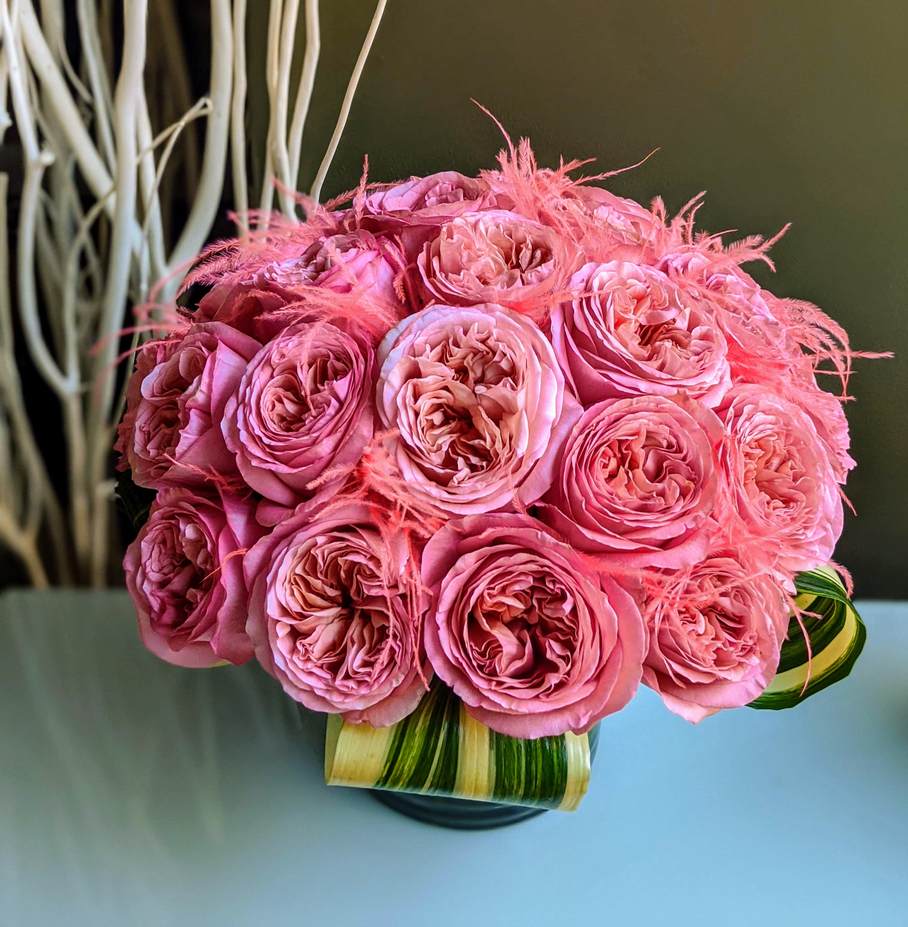 Pink Flamingos Roses    When you want whimsical and wonderful! - This lush pave features 24 incredible dutch imported roses with whimsical and wispy coral feather accents.  Upgrade to Deluxe and include Pink Flamingo Gummies candy and Sour Prosecco Gummy Bears.  Premium upgrade includes the roses and our Love Potion  Scented Candle and Pink Flamingo Gummies.    YUMMY!!!