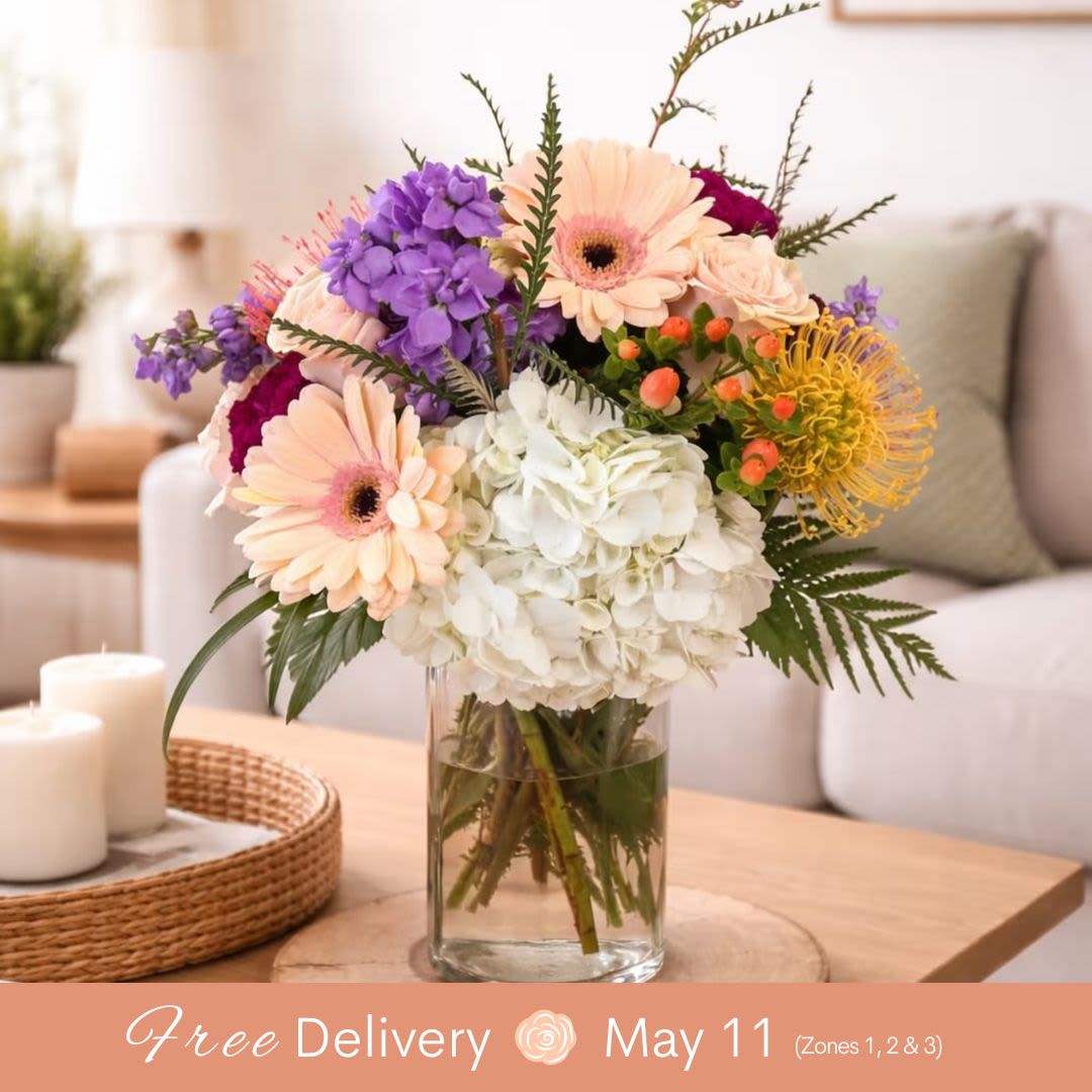 Blushing Blossoms for Mom (Best Seller)  - This Gorgeous Arrangement features a wonderful mixture of roses, hydrangea, and other seasonal flowers, creating a vibrant and heartfelt display that will make any Mom feel truly special! Its perfect size makes it ideal for a dining or coffee table or any desk, brightening up any space with beauty and charm.  Key Features: Beautiful Flower Mix: A thoughtful combination of roses, hydrangea, and other seasonal blooms, perfect for spring or year-round enjoyment. Perfect Size: Ideal for dining tables, coffee tables, or desks, bringing elegance to any space. Makes Mom Feel Special: A beautiful, heartfelt gift to celebrate Mother’s Day or show appreciation. Fresh and Vibrant: The seasonal flowers add freshness and color, making it a perfect addition to any room. .