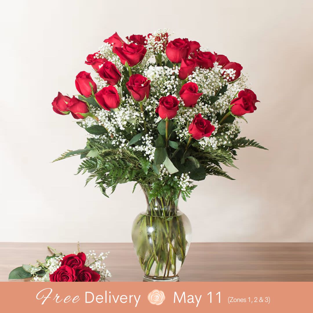  Mom's Red 2 Dozen Premium Masterpiece  - A Beautifully Arranged Masterpiece, this bouquet features two dozen premium South American red roses paired with accent fillers, all elegantly presented in an upgraded glass vase. Perfect for those times when one dozen just isn’t enough!  Key Features: Two Dozen Premium South American Red Roses: Known for their beauty and longevity, these roses are a true symbol of love and admiration. Accent Fillers: Carefully chosen fillers enhance the visual appeal, adding depth and dimension to the bouquet. Upgraded Glass Vase: A sleek and elegant vase that complements the rich colors of the roses, elevating the entire arrangement. Perfect for Special Occasions: Whether it's an anniversary, celebration, or just to make a grand gesture, this arrangement makes a statement. When One Dozen Isn’t Enough: The larger bouquet offers an even more impressive and luxurious display of love.