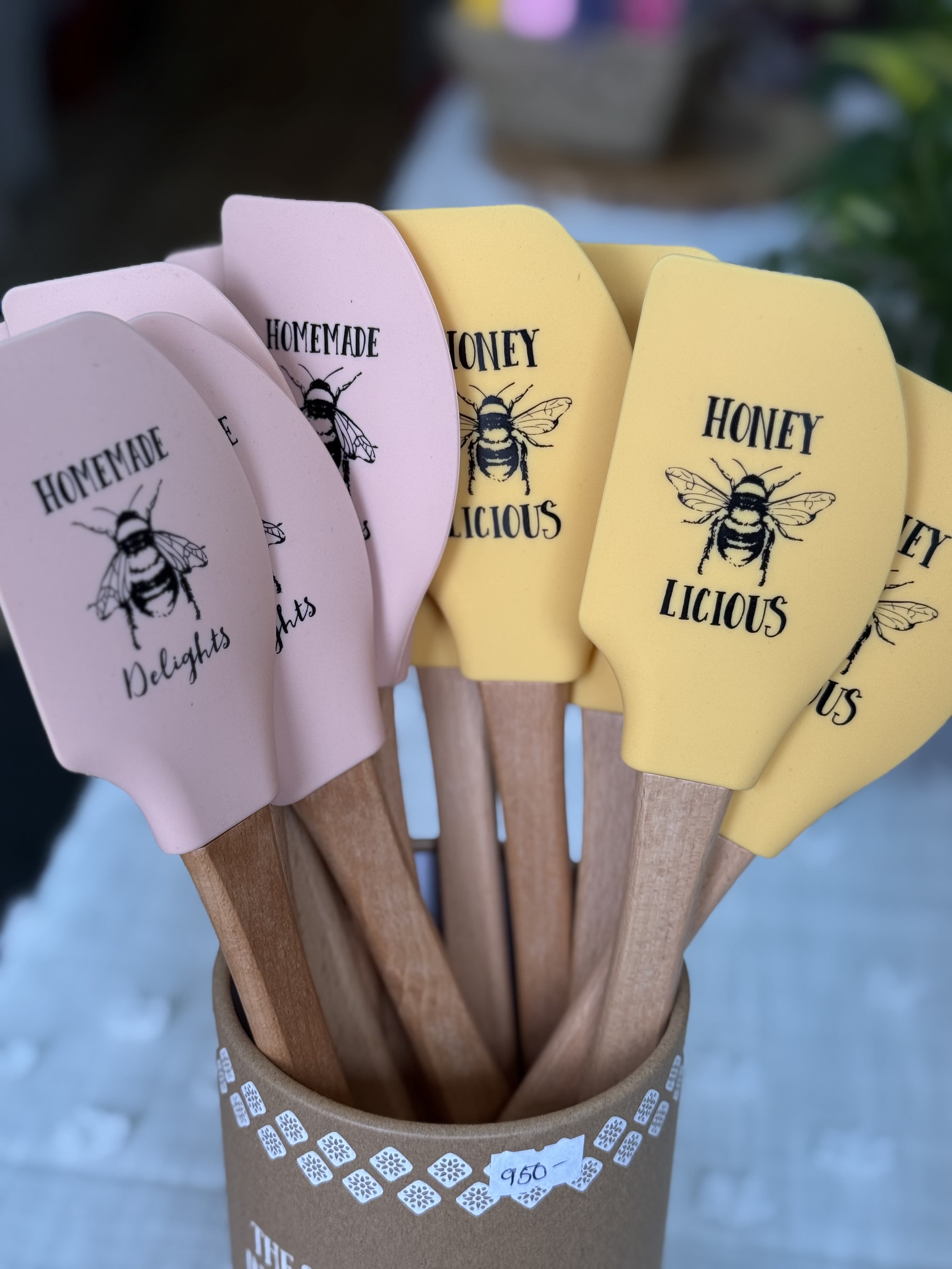Fun Spatula for the Cook - Bright, cheerful pastel spatulas make a playful housewarming or Mother's Day gift that feels both useful and thoughtful. This kitchen-ready arrangement of wooden spatulas is ideal for birthdays, graduation, Father's Day, or "just because" moments when you want the person you're thinking of to smile every time they cook.  The set features wooden-handled spatulas with pale yellow and soft pink silicone heads, each printed with a charming bee illustration and honey-themed text. They're presented upright in a rustic brown paper container for an easy, handmade look that fits autumn and summer kitchens alike. Practical and pretty, this gift works well for new homes, host/hostess presents, or as a lighthearted anniversary, holiday, or thank-you gift.  Perfect for cooks who appreciate both style and function, the spatulas are ready to use straight from the container-no wrapping required. Order for housewarmings, retirements, graduations, or seasonal holidays like Thanksgiving, Christmas, or Valentine's Day; they also make a sweet pick-me-up for get-well, new baby, or thinking-of-you occasions.