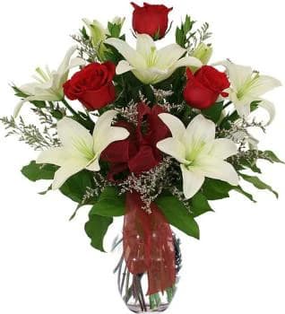 Bouquet of red roses and white lilies in a glass vase
