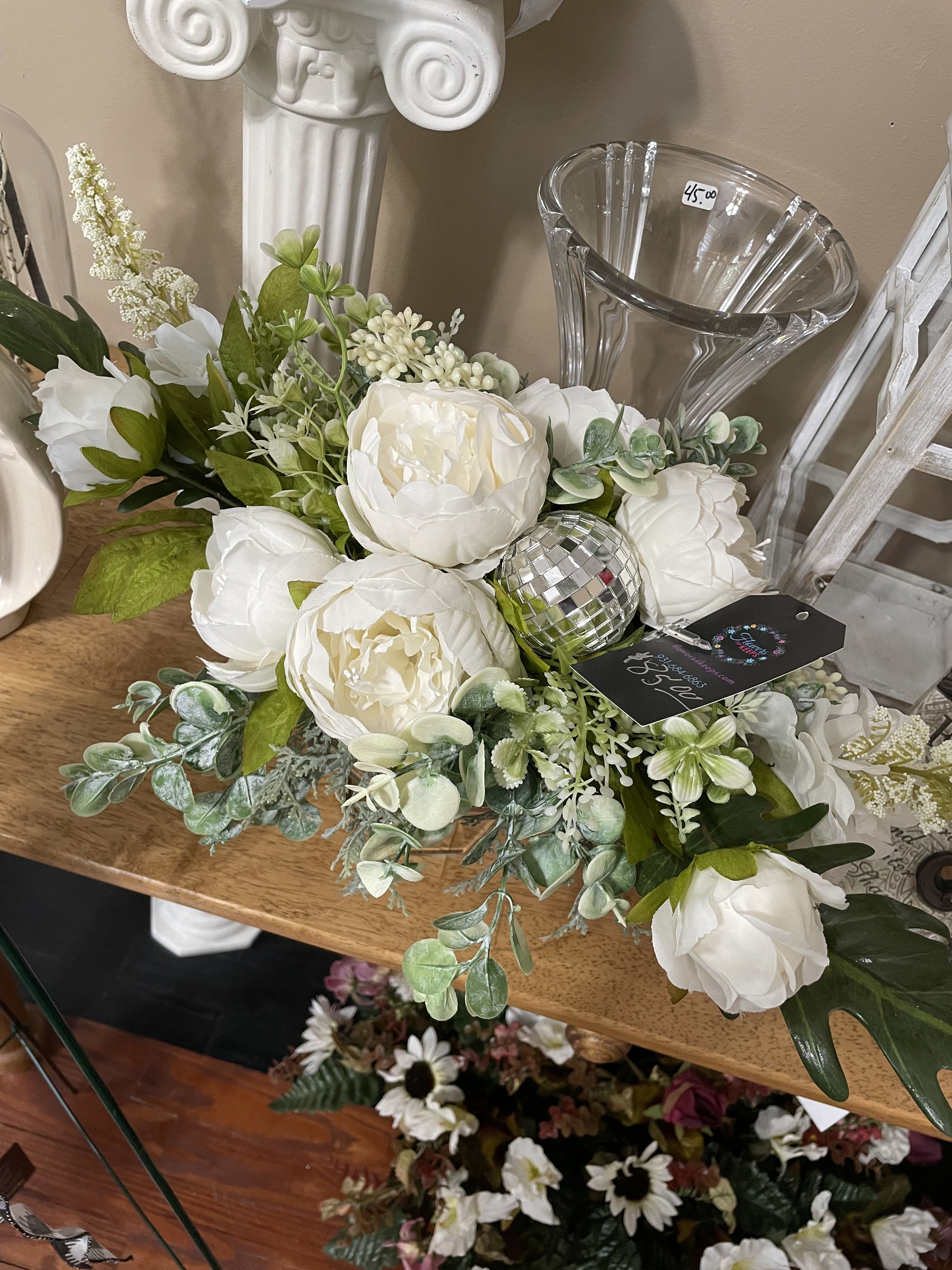 White floral arrangement with peony-like blooms in a clear vase