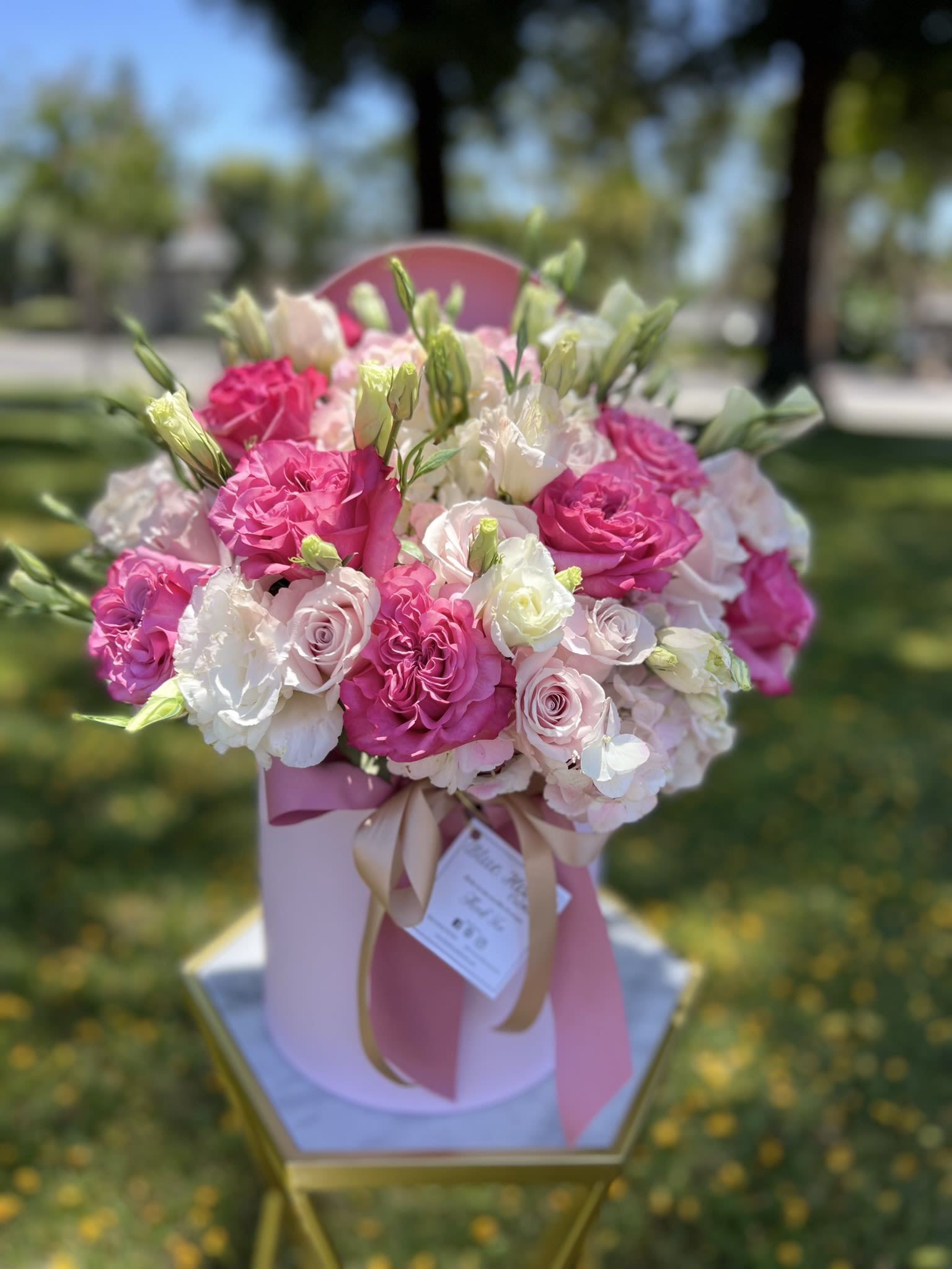 Pink and white rose bouquet in a pink hat box with ribbon