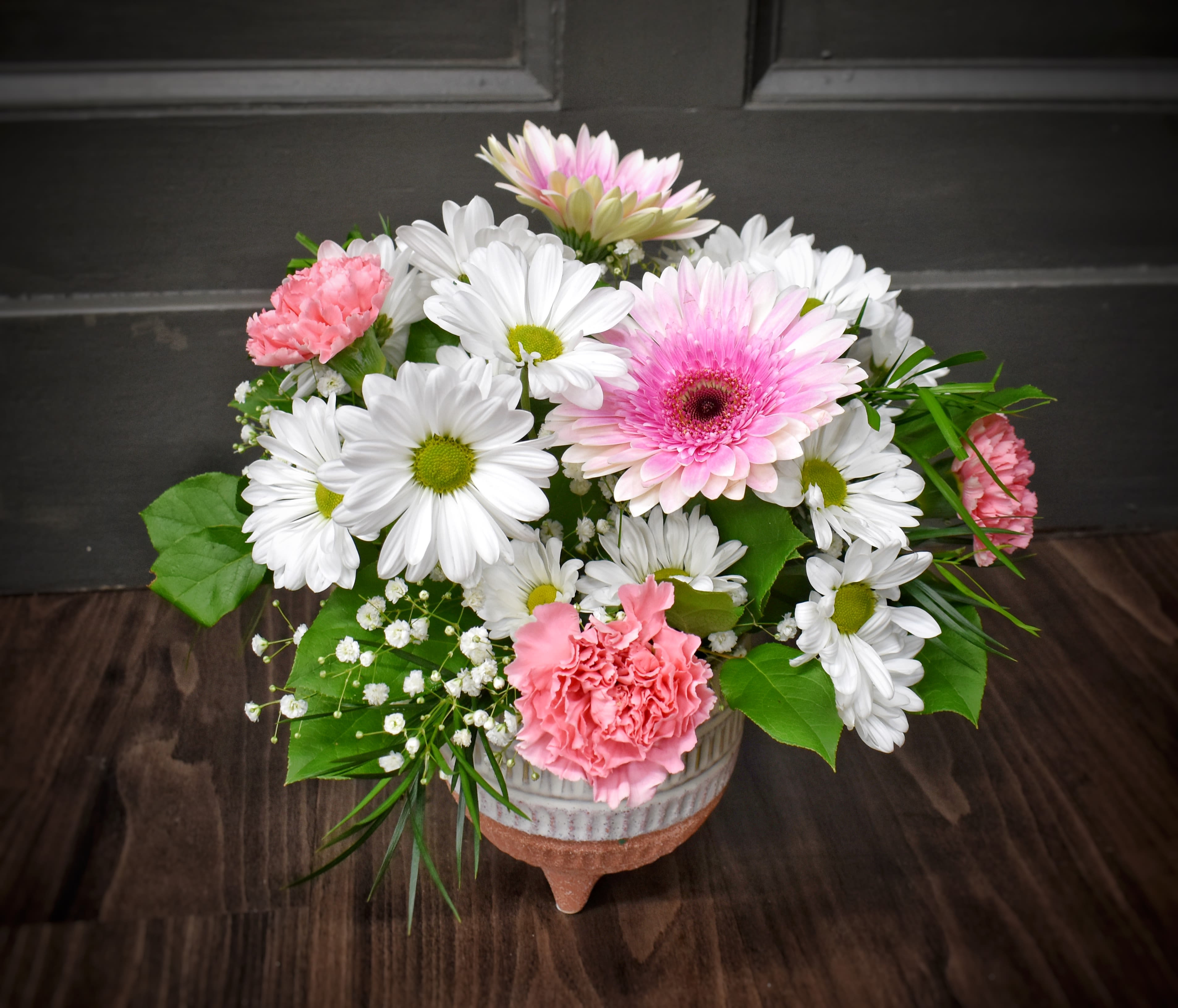Daisy Daydreams - Daydreaming of warm weather and sunny skies? This is the perfect arrangement for you! Enjoy a long-lasting mix of daisies, gerbera daisies and carnations in a keepsake ceramic container.  *note container may vary from pictures