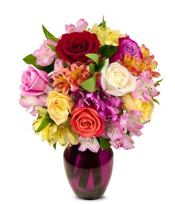 Mixed bouquet of roses and alstroemeria in a purple vase