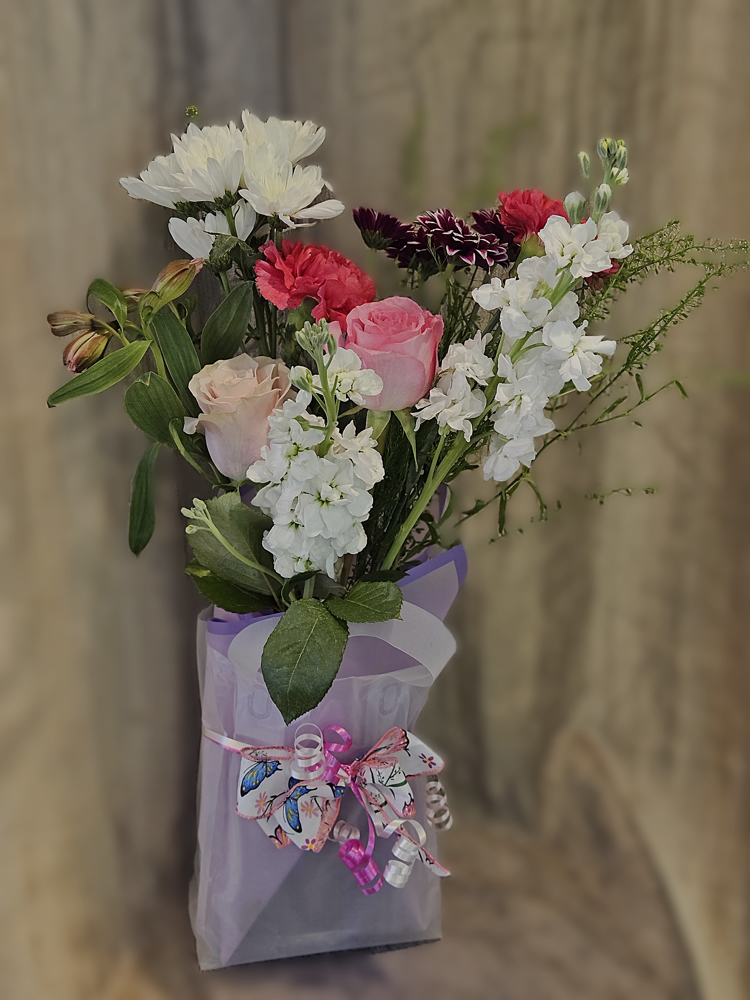 Designer‑In‑Bloom - A thoughtful bundle of blooms presented in a sweet gift bag, created for the mom who prefers to style her flowers her way. It’s an invitation to snip, shape, and create something uniquely hers. Colors may vary from photo