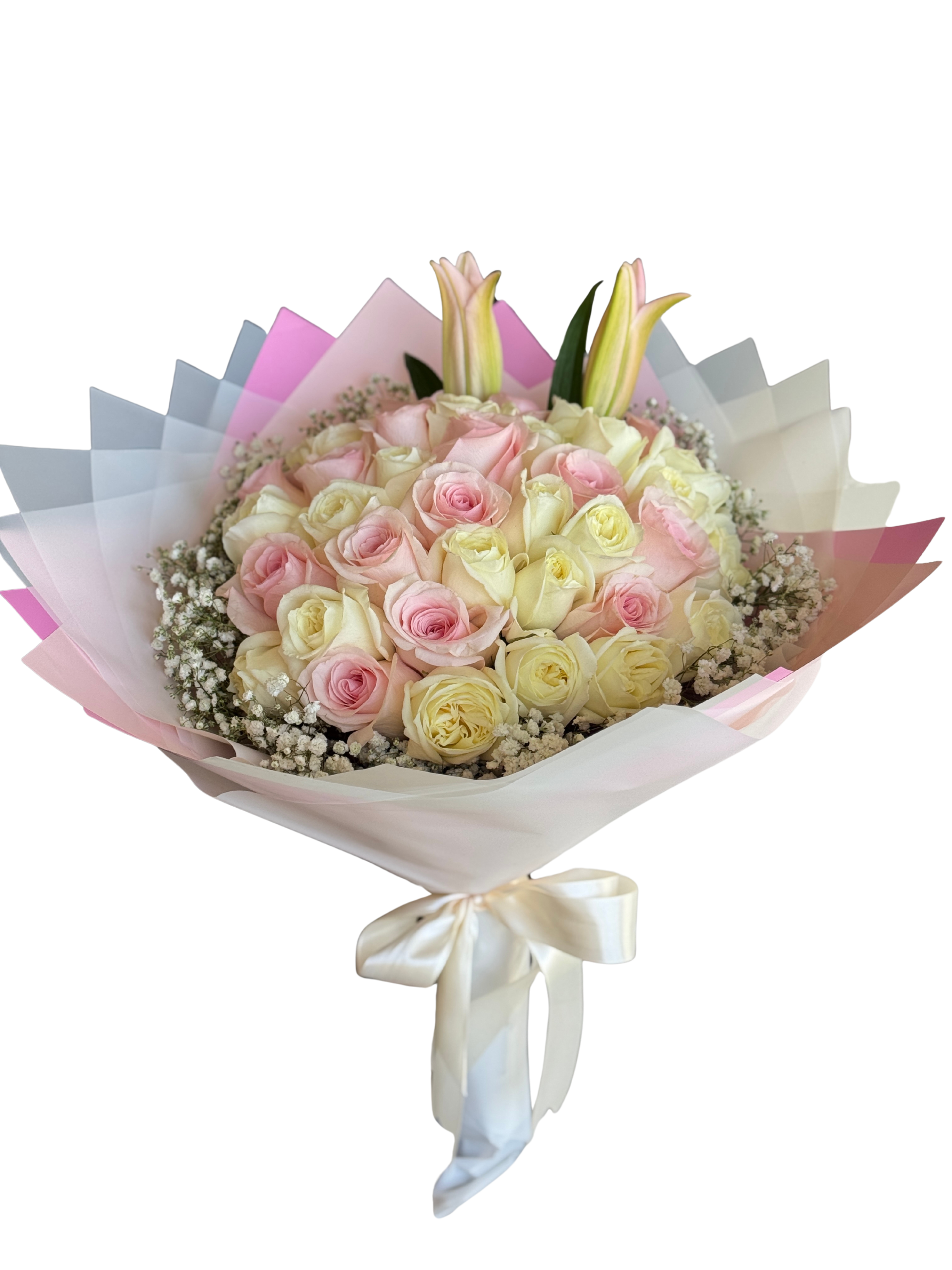 Bouquet 40 roses pink and white  - A lush cluster of forty pink and cream roses creates an instant feeling of warmth and affection-the perfect birthday bouquet or anniversary roses to make her feel truly celebrated. Two pale lilies rise above the rounded, hand-tied form for subtle height and fragrance, while delicate white filler flowers soften the outer edge and reinforce the bouquet's romantic, everyday-premium look.  Wrapped in layered pastel paper and finished with a cream satin ribbon, this arrangement blends pink, white, and soft yellow accents for a gentle, mixed-color palette that reads elegant and thoughtful. The bouquet's rounded shape sits comfortably in the hands and is ideal for presenting in person; its lilies add a touch of drama without overwhelming the roses.  This is a meaningful way to say "thank you," "happy birthday," or "thinking of you" for the special person in your life-especially lovely for Mother's Day or anniversaries. For best enjoyment, trim stems and place in fresh water on arrival; available as shown in the photographed hand-tied size.