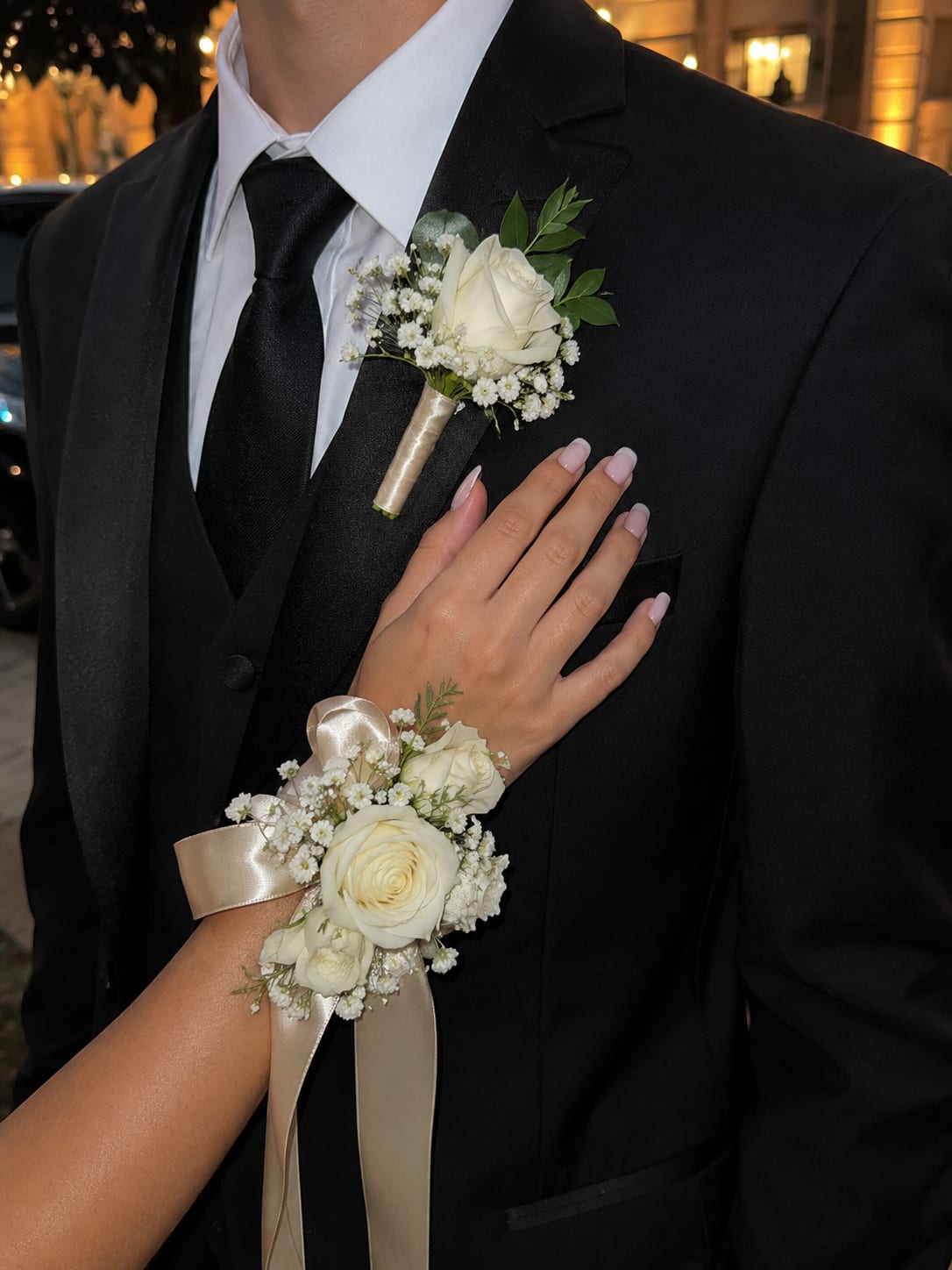 White Pearl Prom Set - This matching corsage and boutonniere set features fresh ivory roses, delicate baby’s breath, and elegant champagne satin ribbon accents, creating a timeless and romantic prom look.   This design can be customized to match your dress or prom colors. Please leave your dress color or inspiration details in the notes section at checkout, and we will create a beautifully coordinated set just for you.   