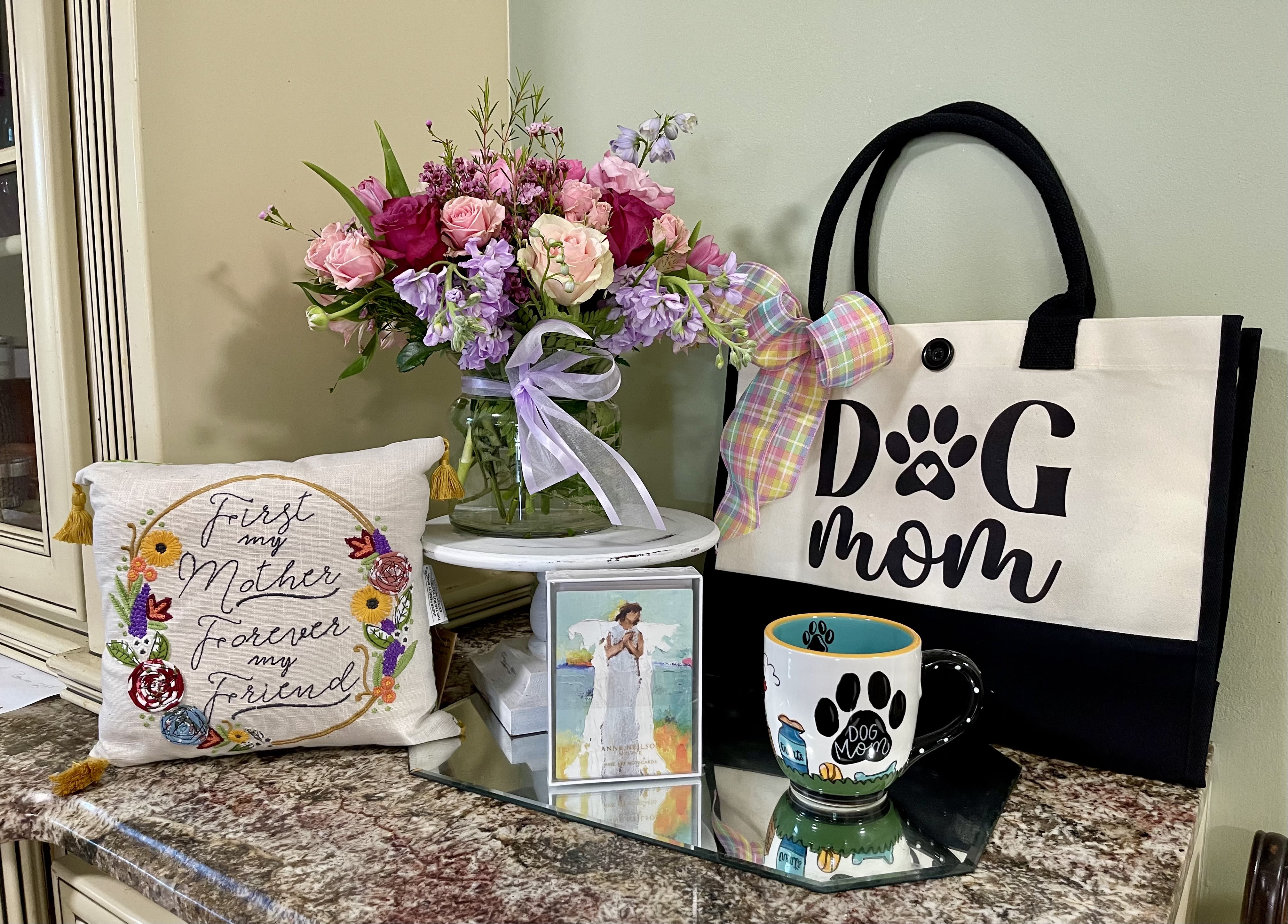 The Legacy Dog Mom Bundle - Celebrate the dog mom who deserves it all this Mother’s Day with our adorable Dog Mom Bundle from Legacy Florals and Gifts   This thoughtfully curated gift set includes: • A beautiful fresh floral arrangement in soft pinks and lavenders • A charming “Dog Mom” tote bag with pastel bow detail • A hand-painted Dog Mom mug perfect for morning coffee • A heartfelt keepsake pillow that says “First My Mother, Forever My Friend” • Beautiful Anne Neilson note cards featuring her trademark Angel print  Perfect for the dog lover who treats her furry friend like family. Whether you’re shopping for Mom, Grandma, a daughter, or your favorite pet parent, this bundle is full of love, beauty, and cozy charm.