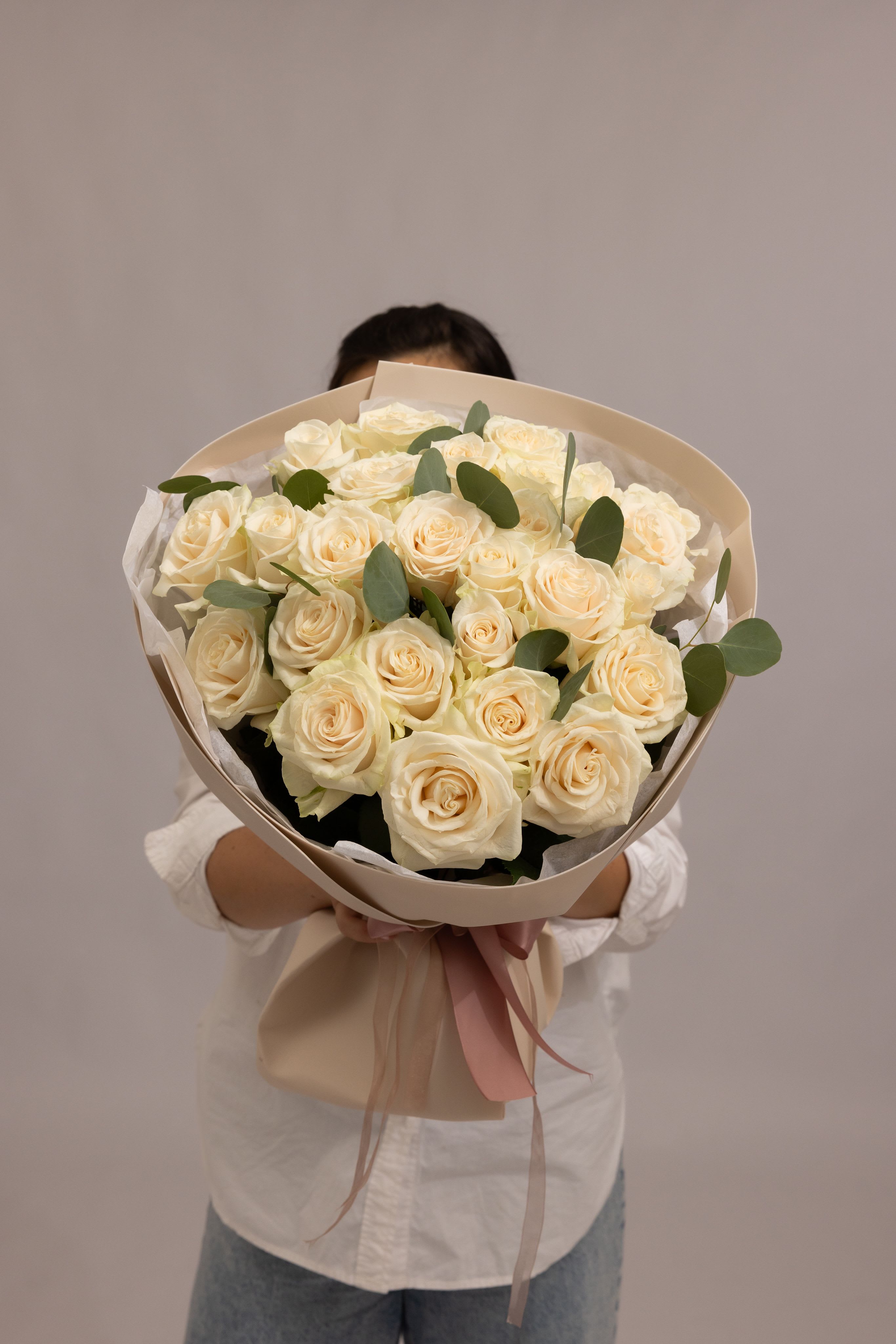 Ivory Aura - A timeless bouquet of 24 premium roses in soft white and ivory tones. Each bloom features a full, layered form, creating a refined and elegant composition that feels both classic and modern. The delicate palette and clean design make this bouquet effortlessly sophisticated—perfect for weddings, celebrations, or expressing pure and graceful emotions. Type: Premium Rose Bouquet NOTE: Please note that wrapping paper color may vary depending on availability. Some flowers in the bouquet may be substituted with similar blooms based on seasonal supply and farm availability. However, the overall style, color palette, and airy composition will always be preserved.
