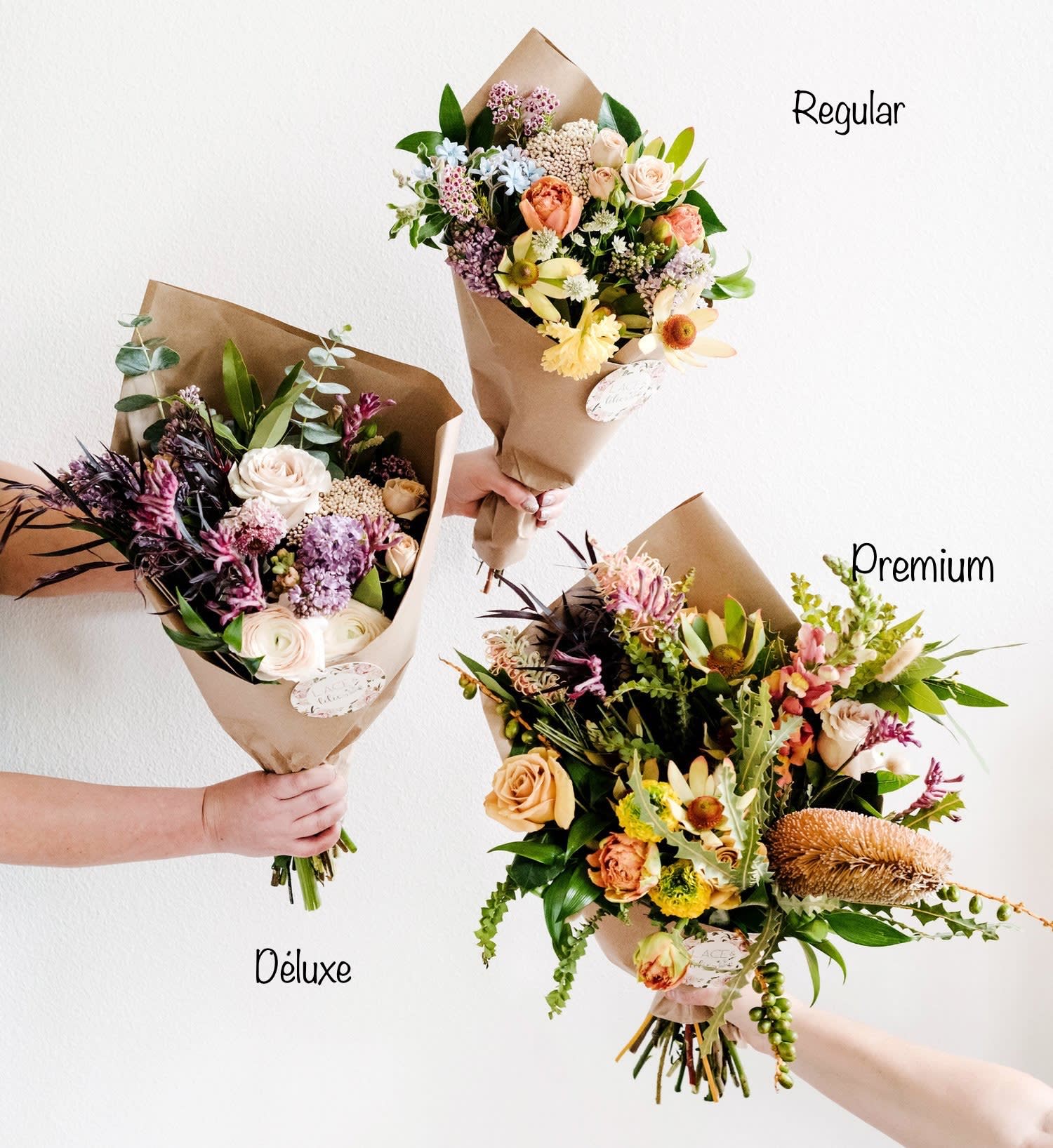 Three wrapped bouquets of mixed flowers in different sizes