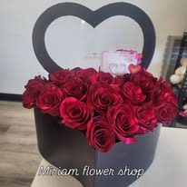 Red roses arranged in a black heart-shaped box