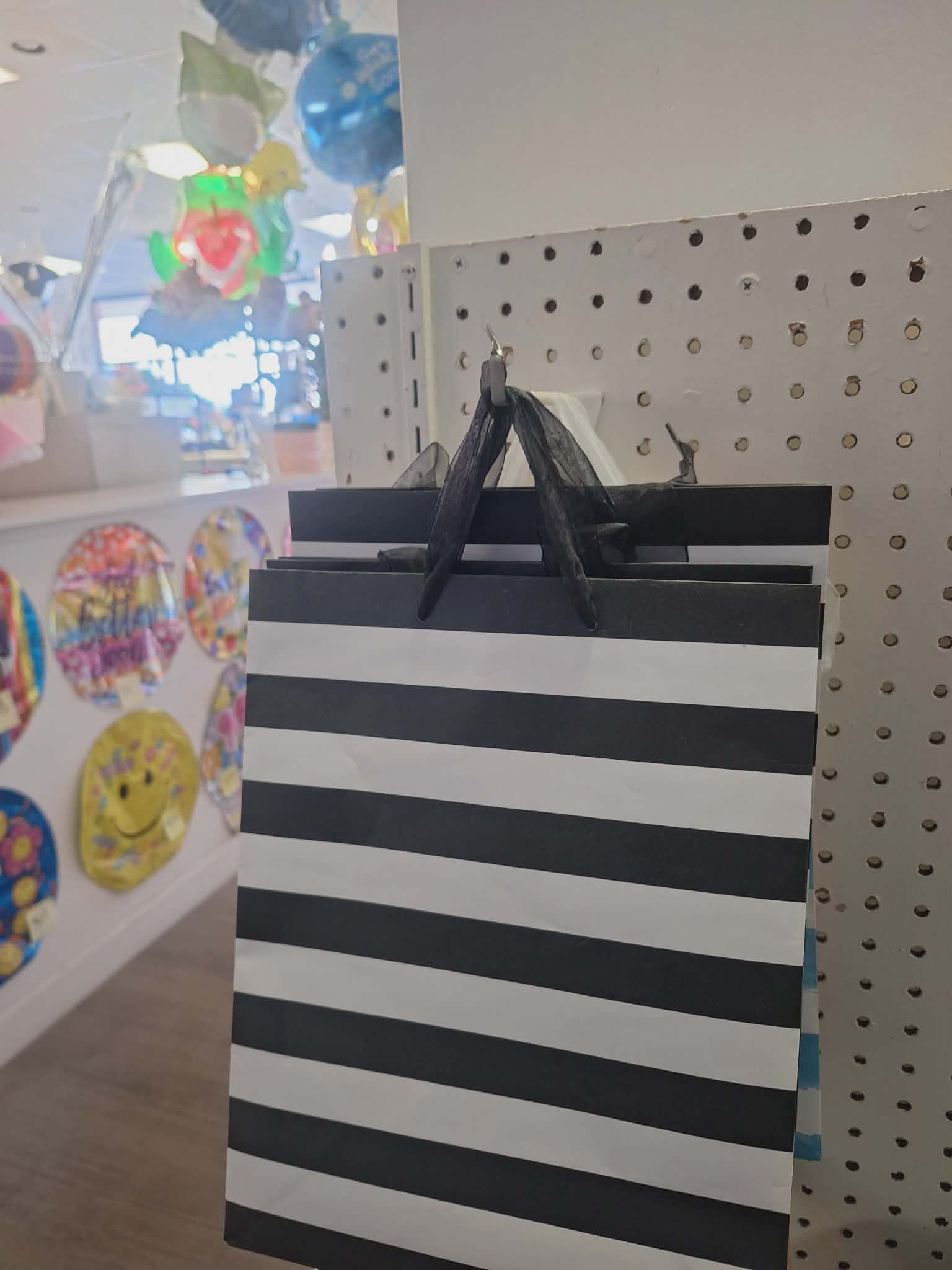 Black-and-white striped gift bag hanging on a display peg