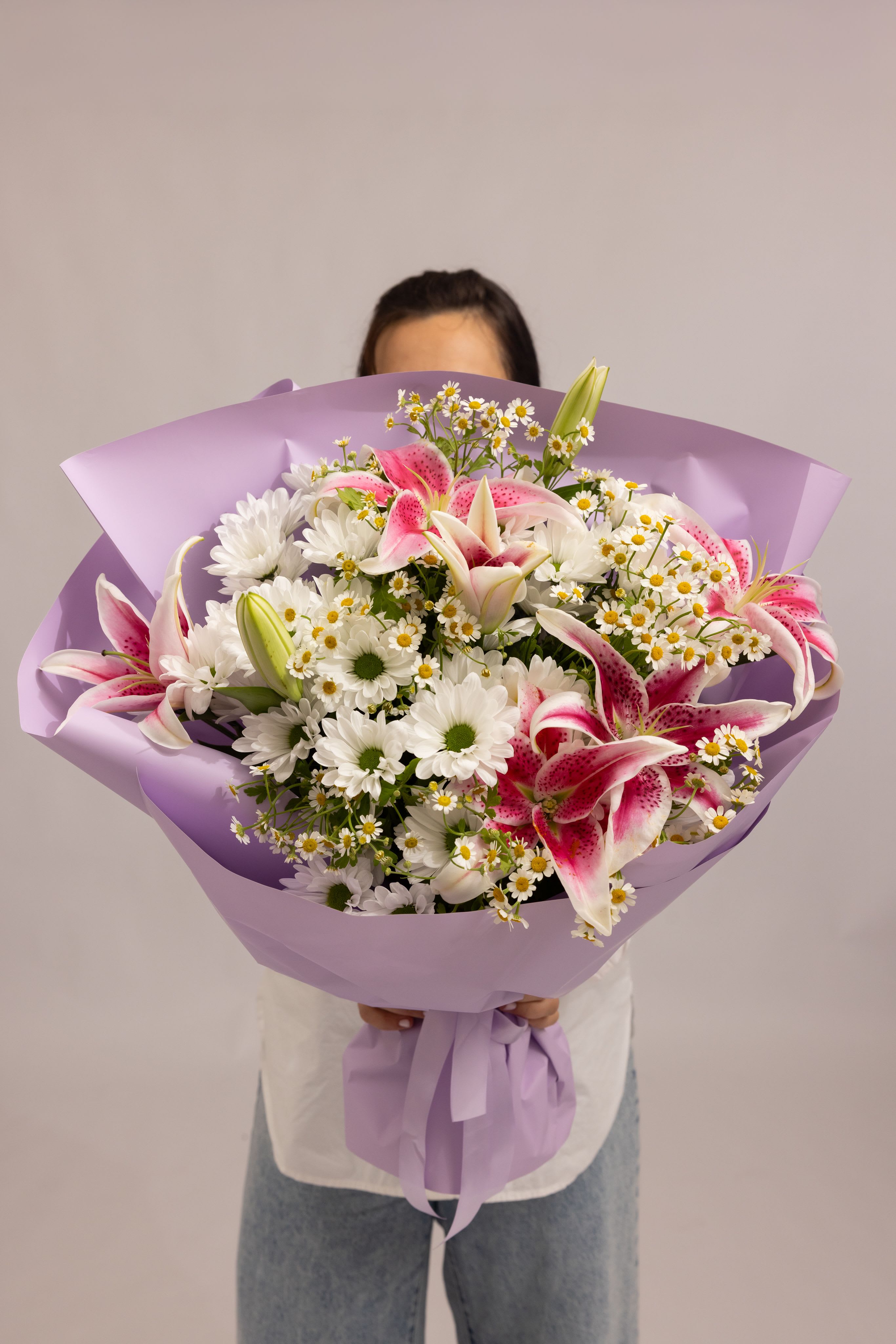 Blush Bloom - A soft and charming bouquet featuring pink stargazer lilies, white starlight daisies, and delicate chamomile accents. The combination of soft pink tones and crisp whites creates a light, airy composition that feels fresh, romantic, and effortlessly elegant. Designed to bring warmth, sweetness, and a natural garden feel to any moment—perfect for thoughtful gifts and special occasions