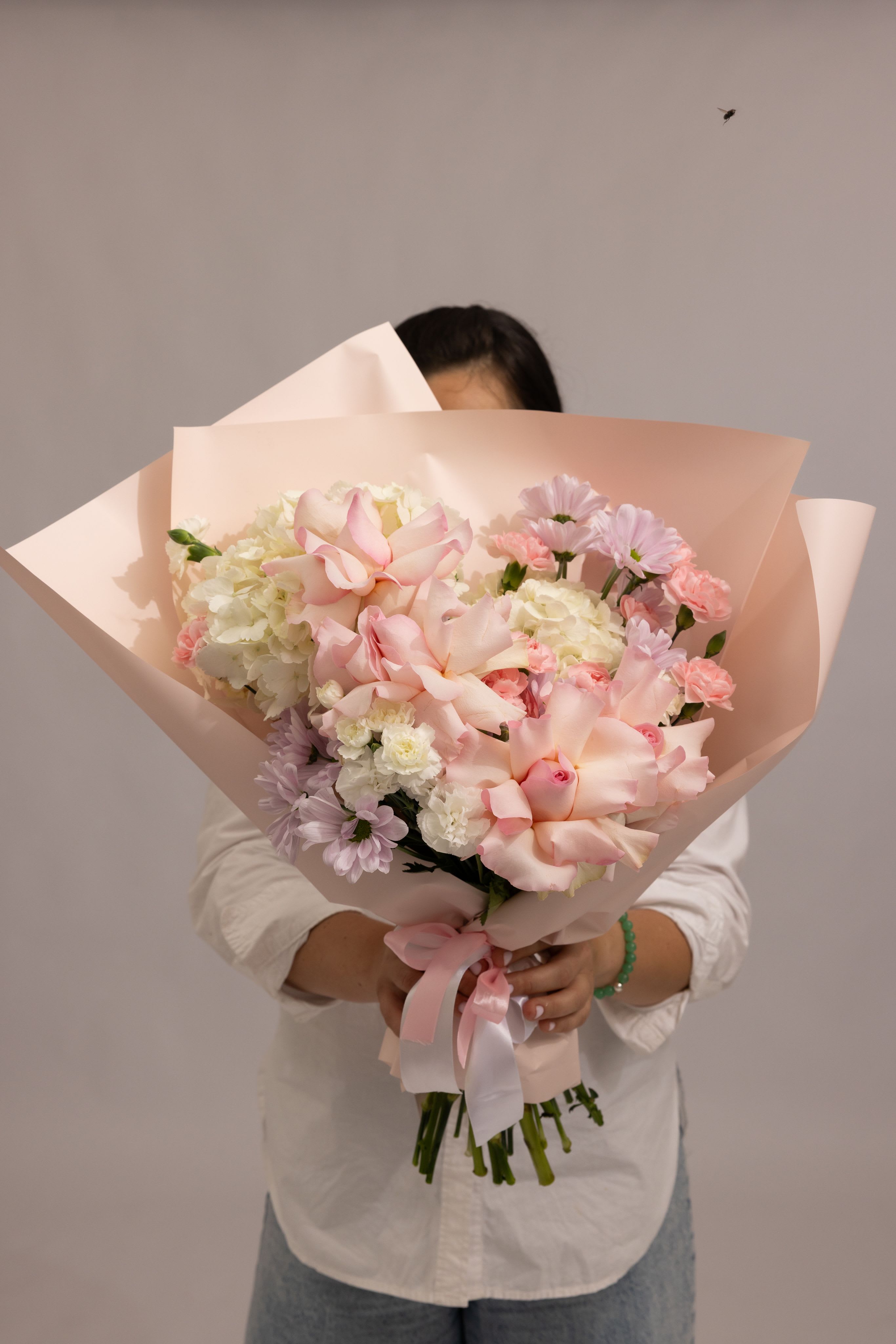 Blush Harmony - A soft and romantic bouquet in delicate blush tones, featuring pink roses, hydrangea, pink spray carnations, white carnations, and airy pink daisy accents. The gentle combination textures and pastel hues creates a light, feminine composition that feels elegant, fresh, and effortlessly graceful. Designed to express tenderness, love, and quiet beauty—perfect for heartfelt moments and meaningful gestures