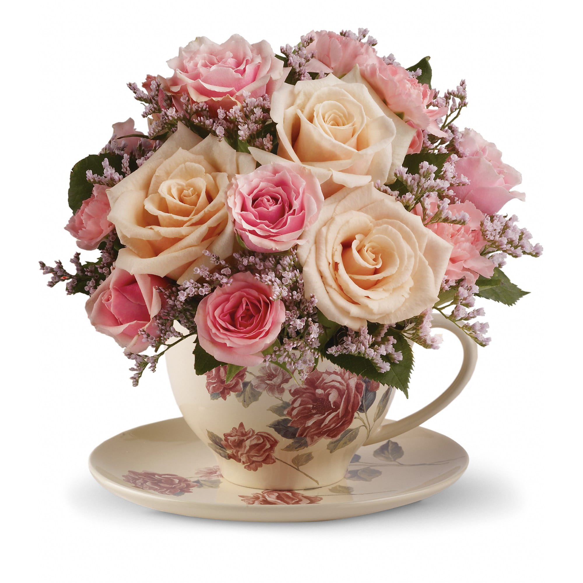 Pink and cream roses arranged in a floral teacup with saucer