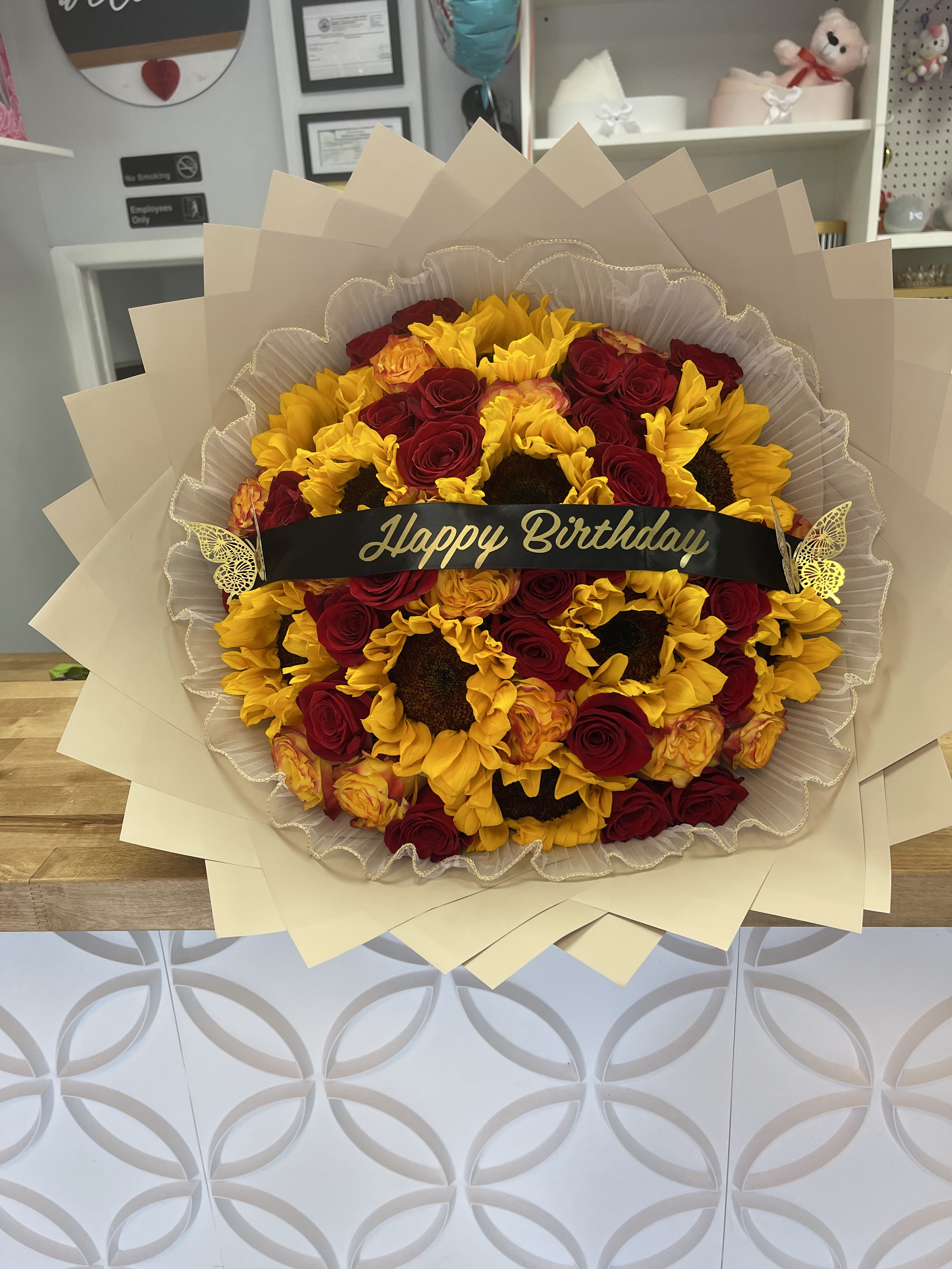 Bouquet of red roses and yellow sunflowers with a Happy Birthday ribbon