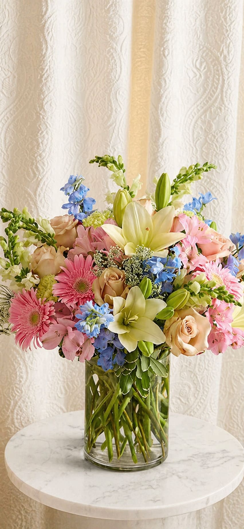  Dream Garden  - Especially for mom. This dream garden arrangement made with delphinium , roses ,  Lilies, gerbera daisy, queen Ann lace and snap dragoon , arrange in a cylinder vase .
