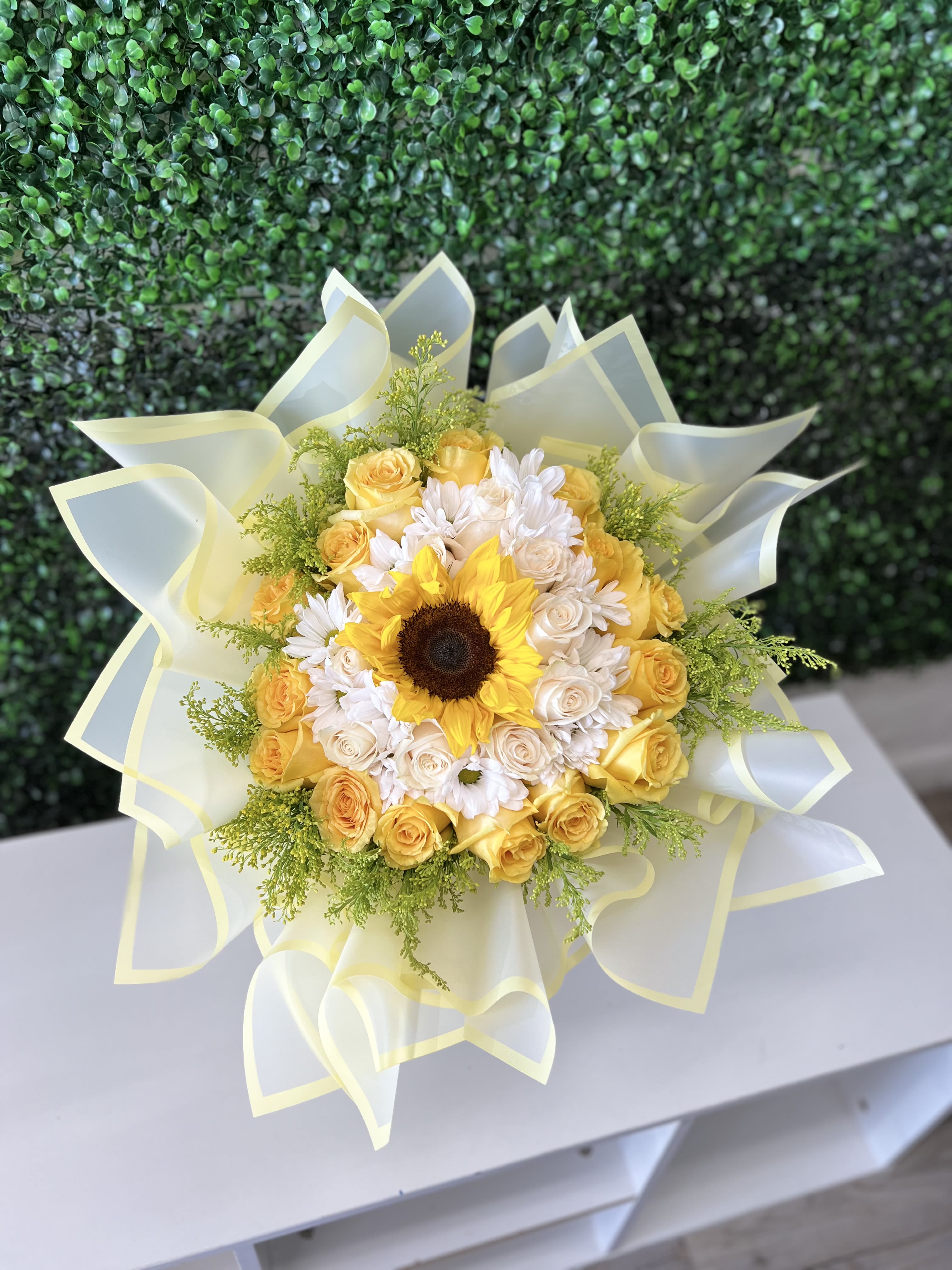 Sunflower springs  - A springtime bouquet with 24 mixed yellow and white roses with one sunflower wrap in light yellow paper, perfect for any and all occasions 