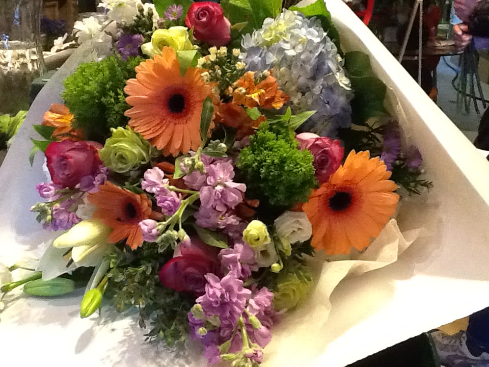 Mixed bouquet with orange gerbera daisies, roses, and purple flowers