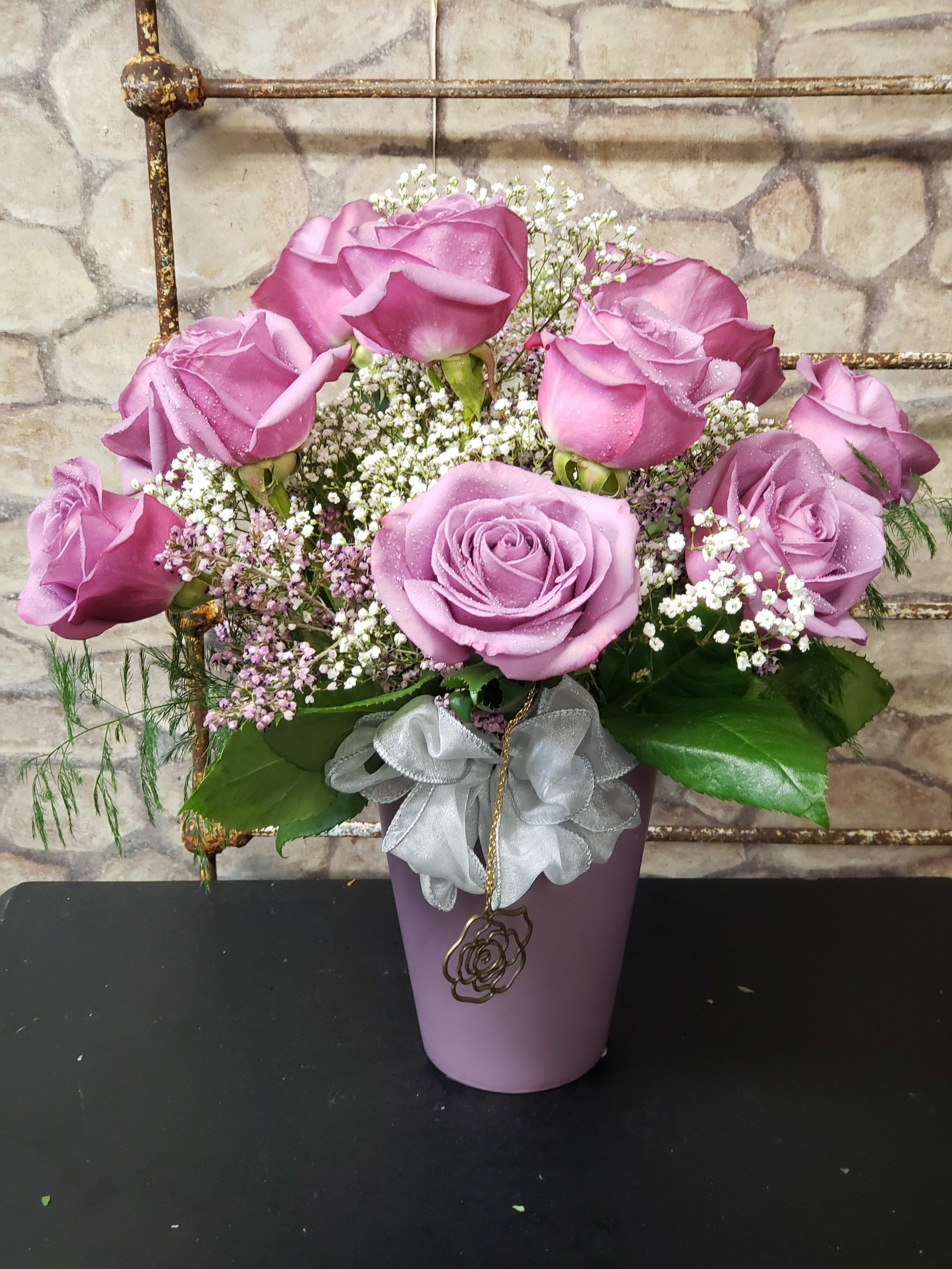   Lavender Cool Water  - Lavender Rose's are limited or not in stock for Holiday weeks! Designed in a clear glass vase. Ceramic Keepsake as shown is now sold out.  LIMITED COLOR CHOICE &amp; CONTAINER STYLE IN PHOTO. Vase shown is very limited...Clear or colored glass vase substitute.  This one-of-a-kind design has one dozen Lavender Coolwater or another hybrid of lavender Rose's, Gyp, mixed greens and holiday accent. 