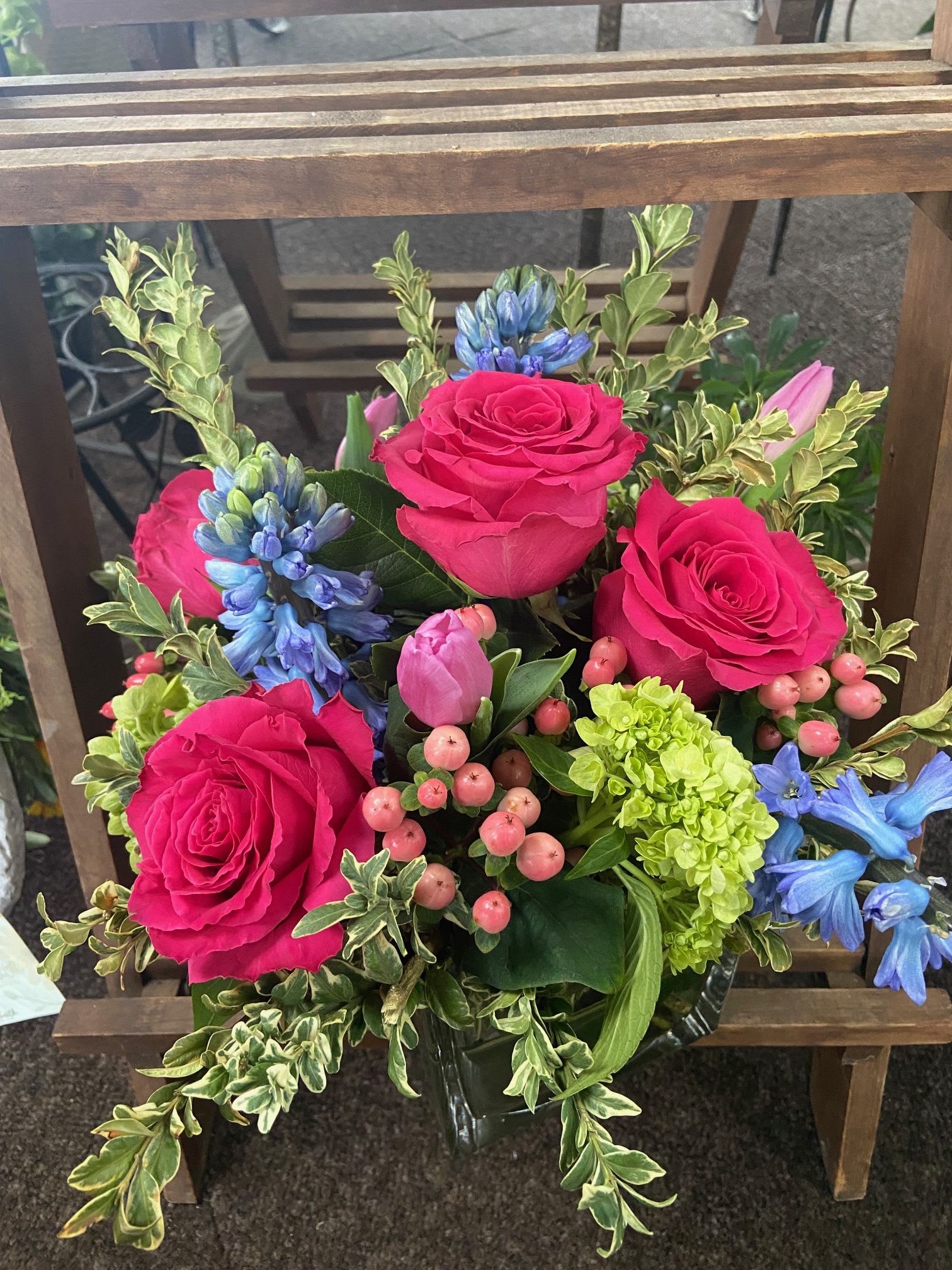 Blushing Spring Cube - Mix of Full Monty roses, tulips, green hydrangeas and hypericum accented with stunning blue hyacinths (when available) or Iris in a leaf lined 6" cube.