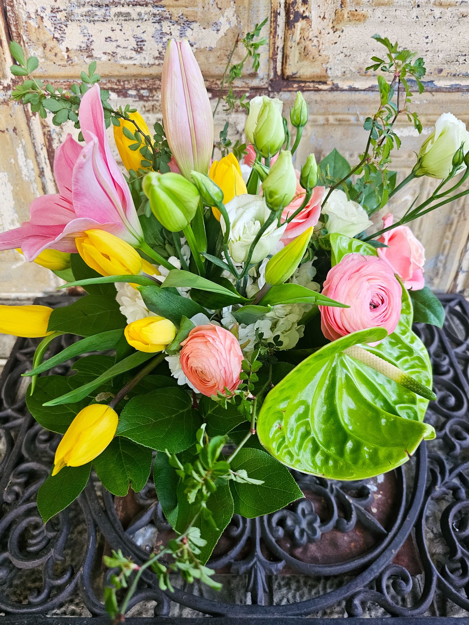 Mixed bouquet with pink and yellow tulips, pink ranunculus, and white blooms
