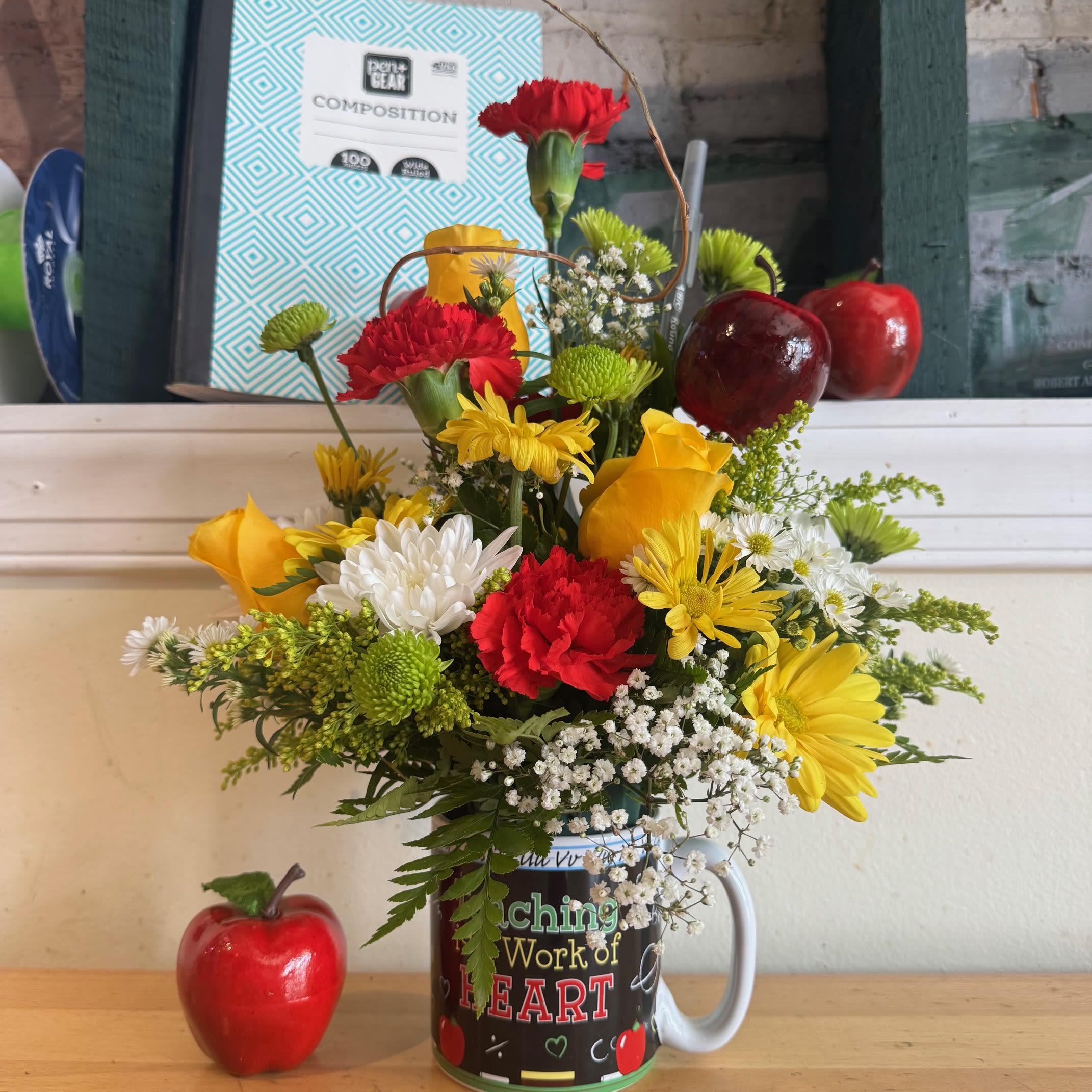 Colorful bouquet in a mug with red and yellow flowers and apple decorations