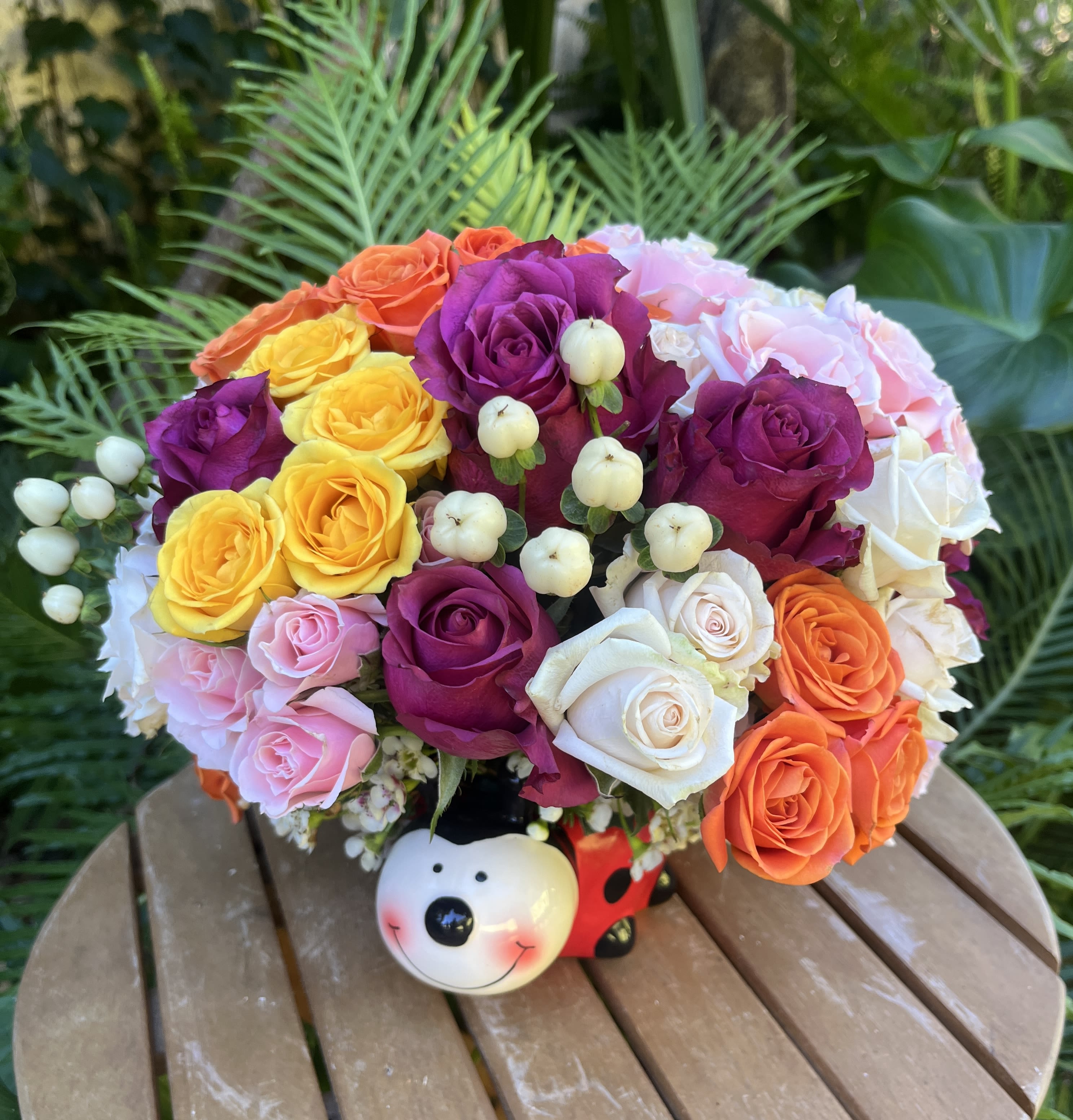 Colorful rose bouquet in a decorative bear-shaped container