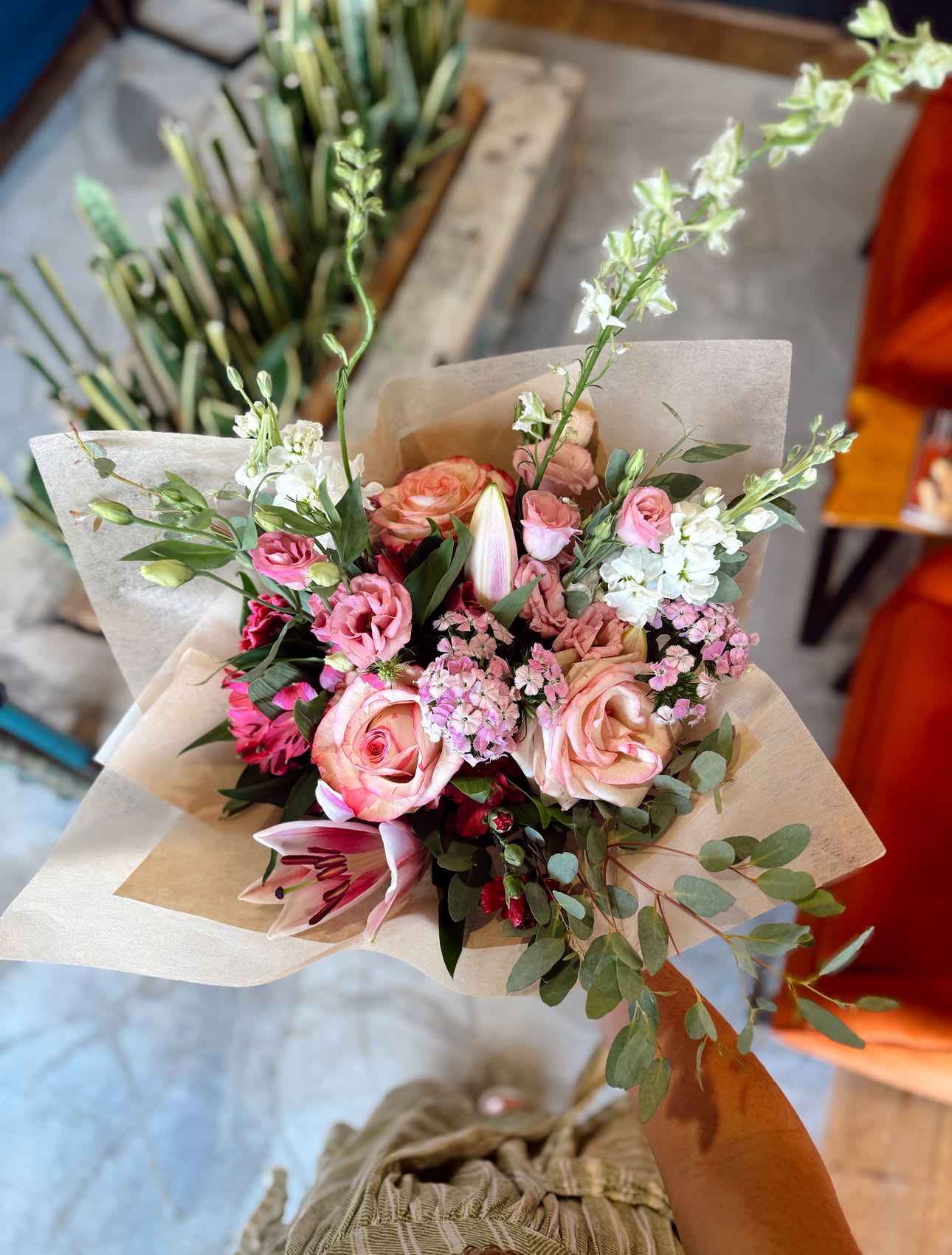 Hand-tied bouquet of pink and white flowers wrapped in paper