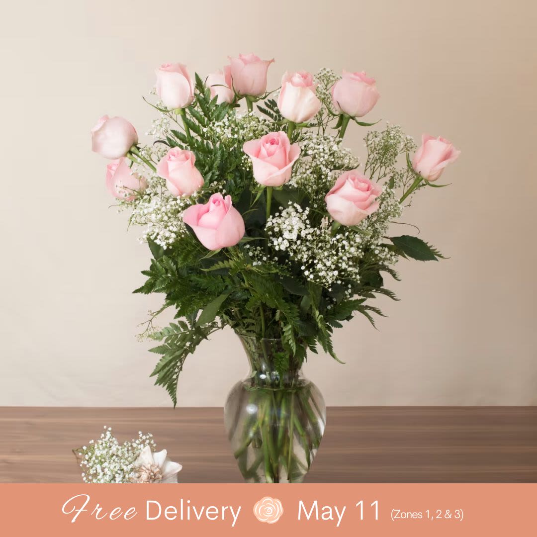 Pink roses in a glass vase with baby's breath