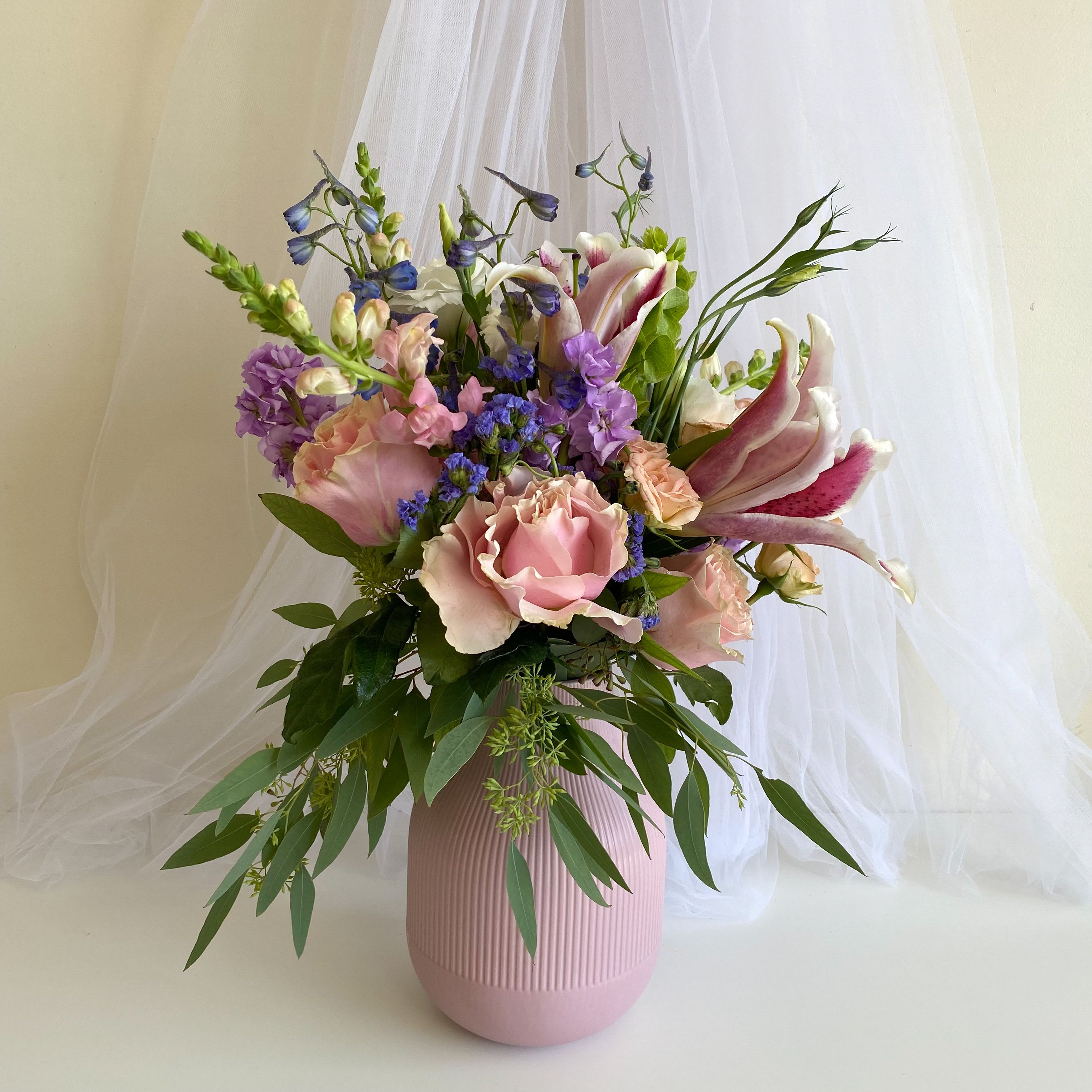 Pink and purple floral arrangement in a ribbed vase