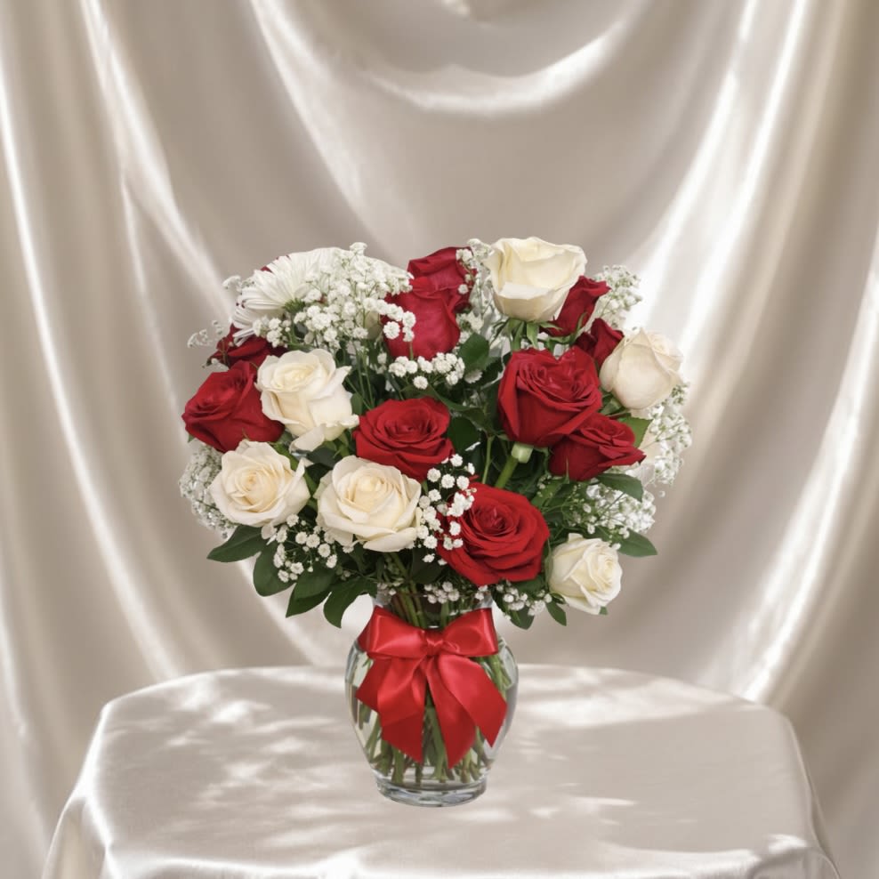 Red &amp; White Rose Vase - A timeless flower arrangement featuring a beautiful mix of red and ivory roses, accented with delicate baby’s breath and lush greenery. Designed in a clear glass vase, this elegant piece offers a refined and graceful look that never goes out of style.  Each arrangement is Designer’s Choice, thoughtfully created with fresh seasonal blooms. Flower varieties and color tones may vary based on availability while preserving the overall style, palette, and quality.  Perfect for Valentine’s Day, anniversaries, birthdays, romantic gestures, thinking of you, congratulations, thank you, apologies, or a meaningful “just because” surprise.  Same day flower delivery available in Southwest Florida, including Naples, Bonita Springs, and Fort Myers Beach.