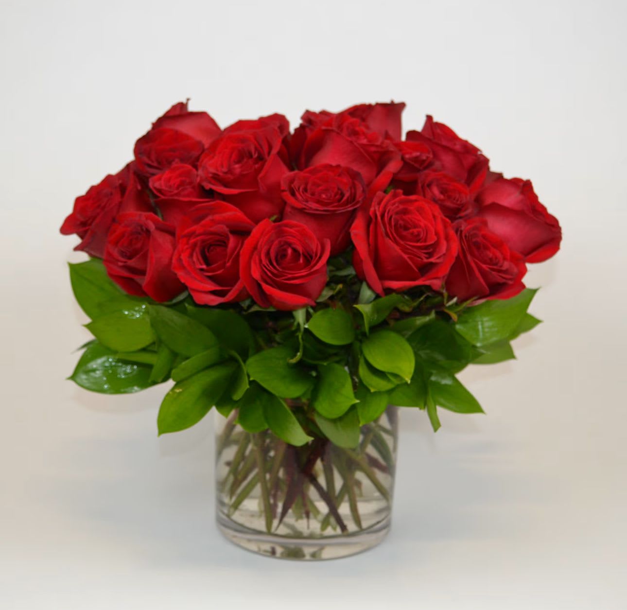 Red roses arranged in a clear glass vase