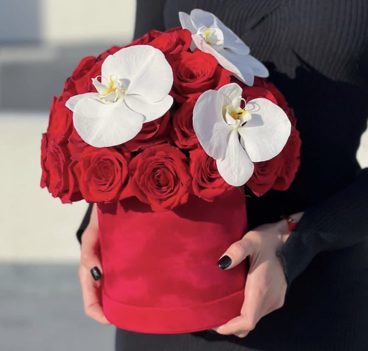 Red rose bouquet with white orchids in a red hat box