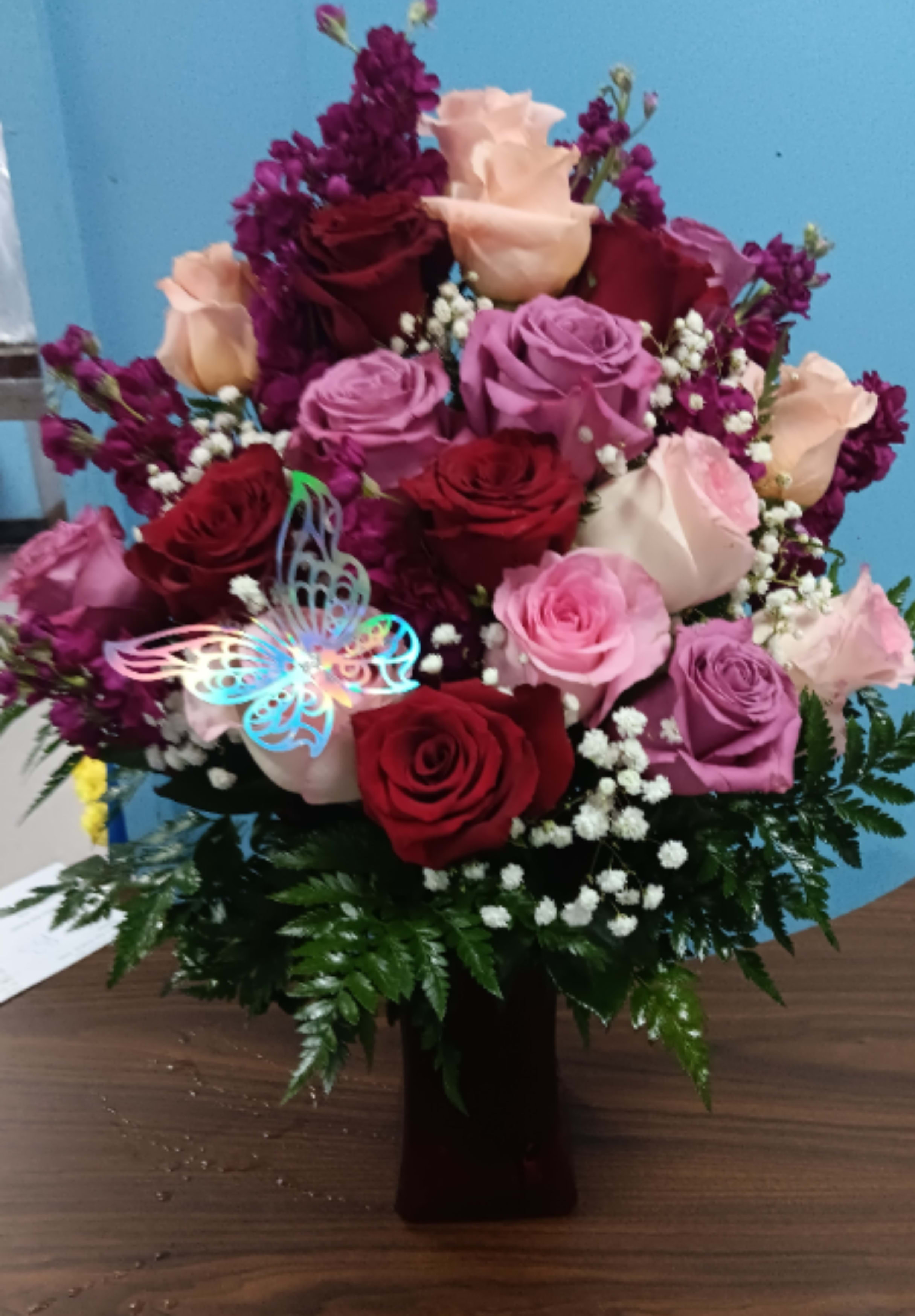 LouAnne - Utterly romantic and blossoming with your love through every blushing bloom, this gorgeous rose bouquet is out to convey your heart's every wish. Hot pink, red, and lavender roses mingle with fragrant fuchsia gilly flowers, beautifully accented with lush greens while seated in a vibrant pink glass vase. The perfect anniversary, "I love you," or Valentine's Day gift! GOOD bouquet includes 9 stems. Approx. 14"H x 11"W. BETTER bouquet includes 12 stems. Approx. 15"H x 11"W. BEST bouquet includes 17 stems. Approx. 16"H x 12"W. EXQUISITE bouquet includes 24 stems. Approx. 17"H x 14"W. 