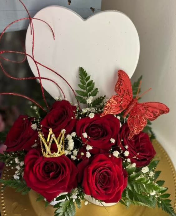 Red roses arranged with a gold crown and red butterfly in a heart-shaped box
