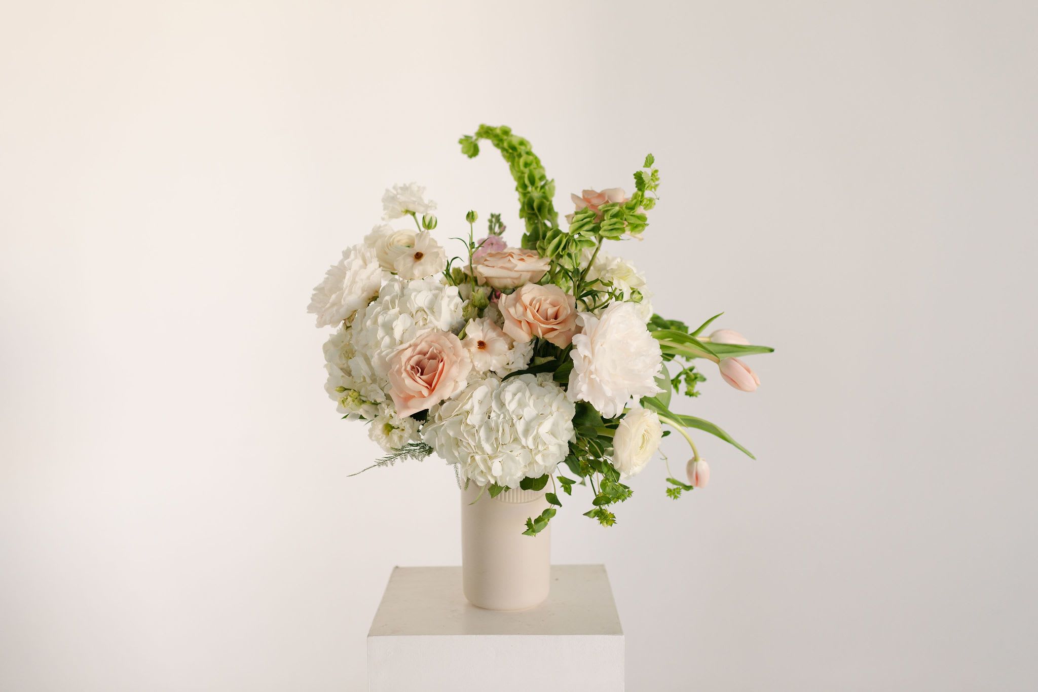 Blush Tall Spring Vase Arrangement - A sweet, pretty arrangement with a sassy edge, this modern twist on a classic blush vase arrangement is perfect for anyone you know who appreciates a timeless aesthetic but with a bit of je ne sais quoi on the side...  Occasionally, we may need to substitute individual blooms depending on quality and seasonal availability, we will always replace individual flowers with blooms of equal or higher value.