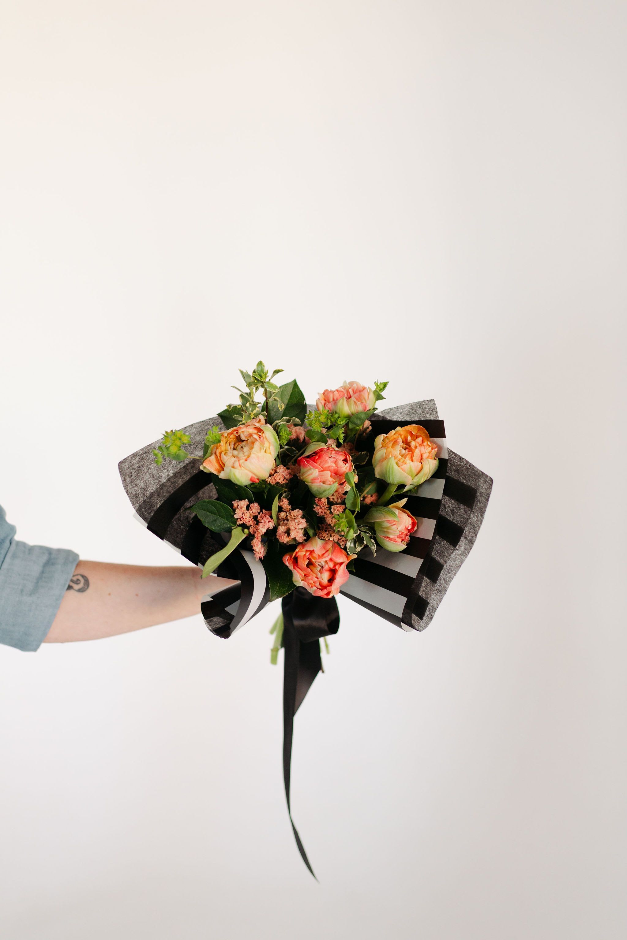 Half-Dozen Tulips - Simple, but never boring! Tulips are the perfect spring bloom, and we use premium peony tulips in this arrangement with smaller spring blooms and fresh greenery to enhance this classic arrangement.  Please let us know if you have a preferred color and we will try to accommodate, depending on availability.