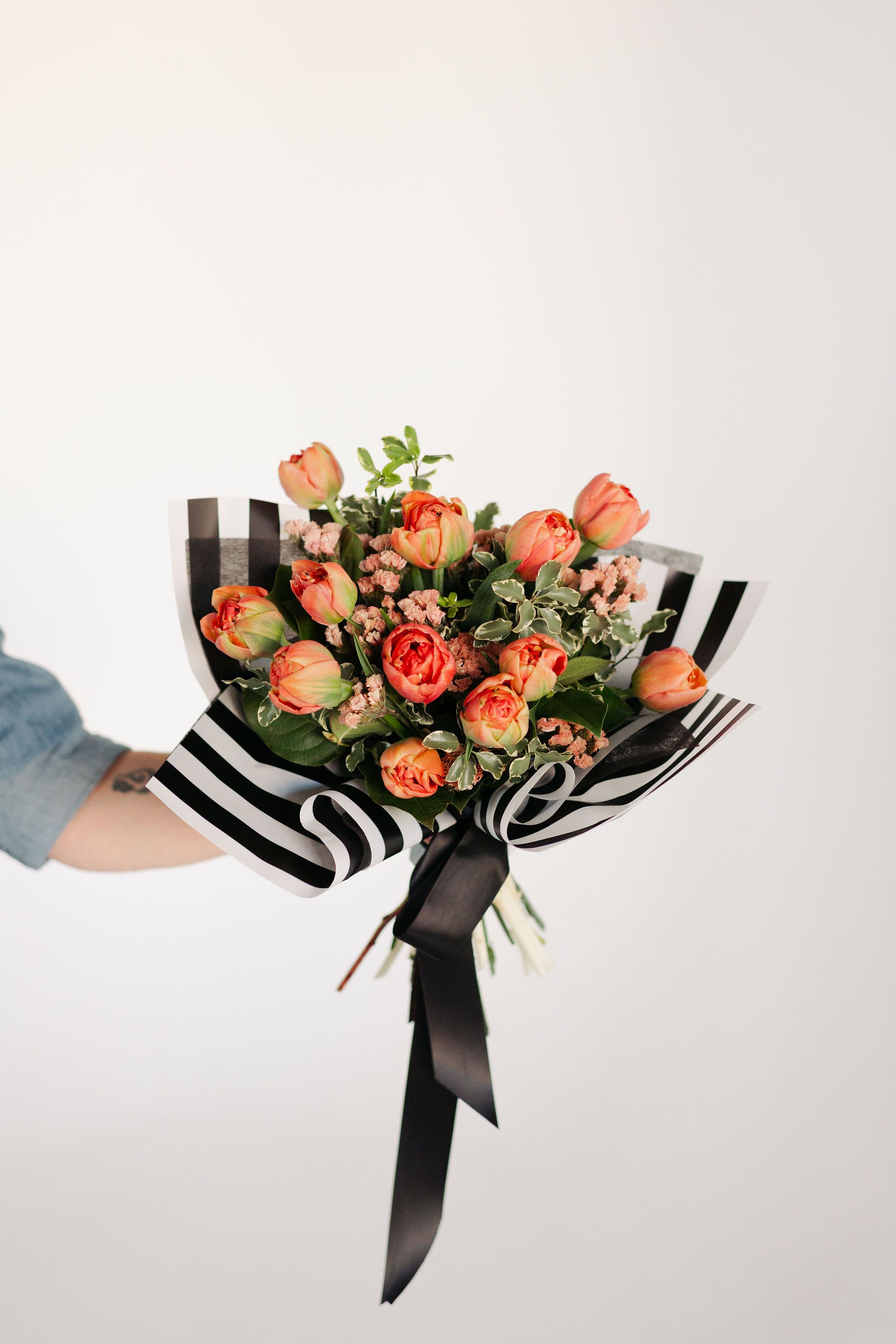 One Dozen Tulips - Simple, but never boring! Tulips are the perfect spring bloom, and we use premium peony tulips in this arrangement with smaller spring blooms and fresh greenery to enhance this classic arrangement.  Please let us know if you have a preferred color and we will try to accommodate, depending on availability.
