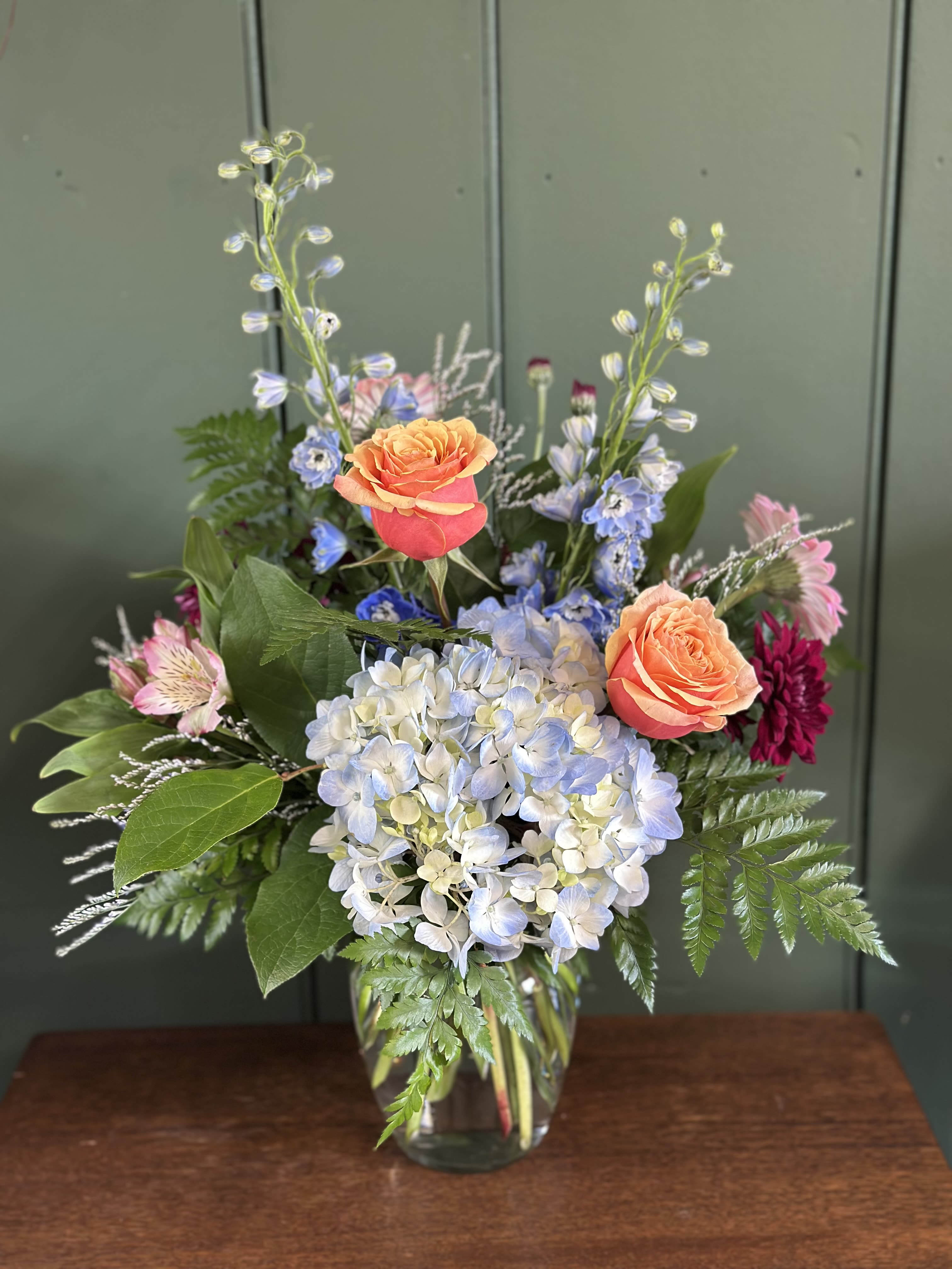 Blue Skies &amp; Day Dreams - A garden inspired arrangement featuring soft blue hydrangea, peach roses, and delicate seasonal blooms in an airy design just like the spring skies and sweet daydreams. 
